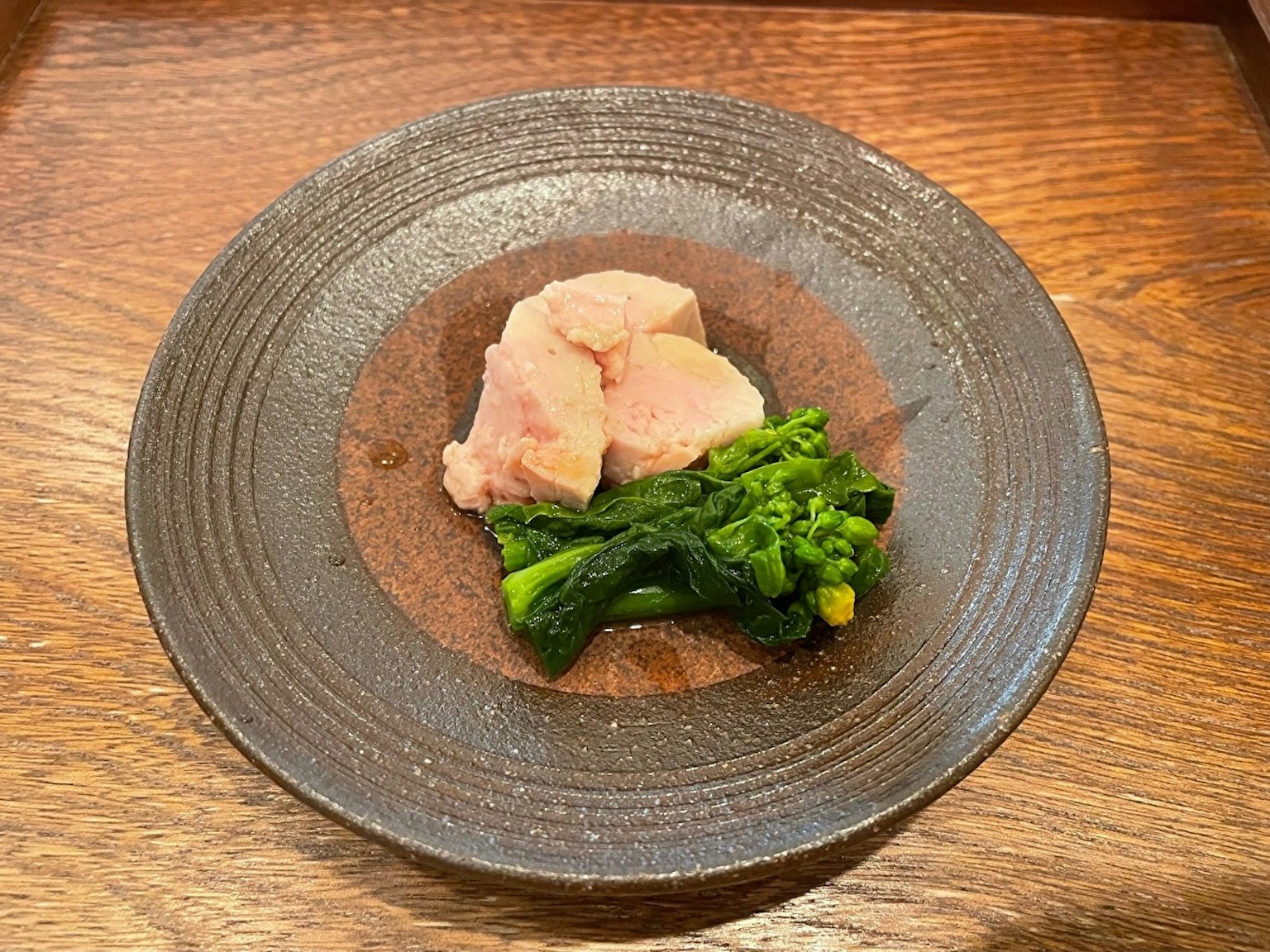 鸡肉和绿色蔬菜盛在漂亮的黑色盘子上