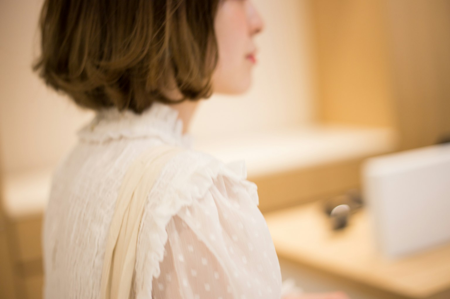 Profil d'une femme portant un chemisier blanc avec un arrière-plan doux