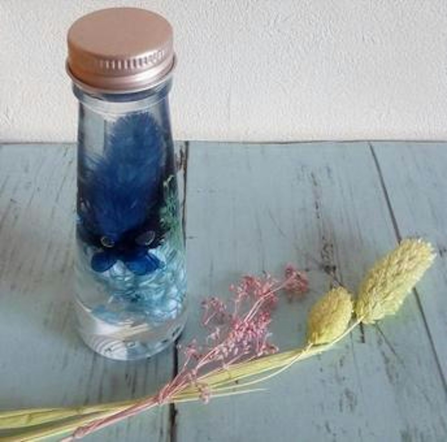 透明瓶子與藍色裝飾和乾花佈置