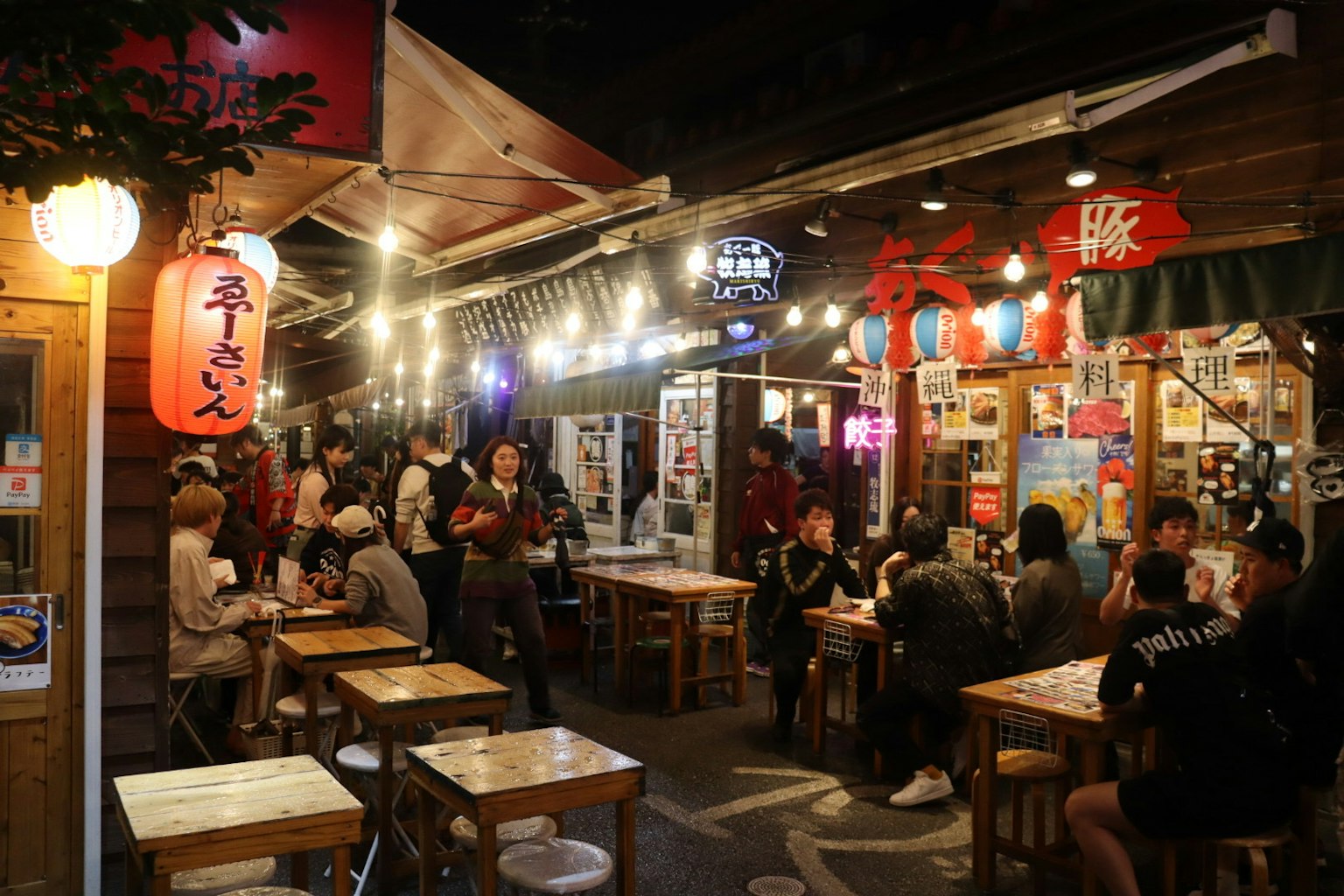 Scena vivace di mercato notturno con persone e lanterne luminose