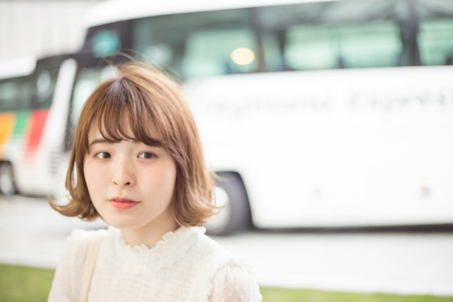 背景为白色公交车的微笑女性肖像