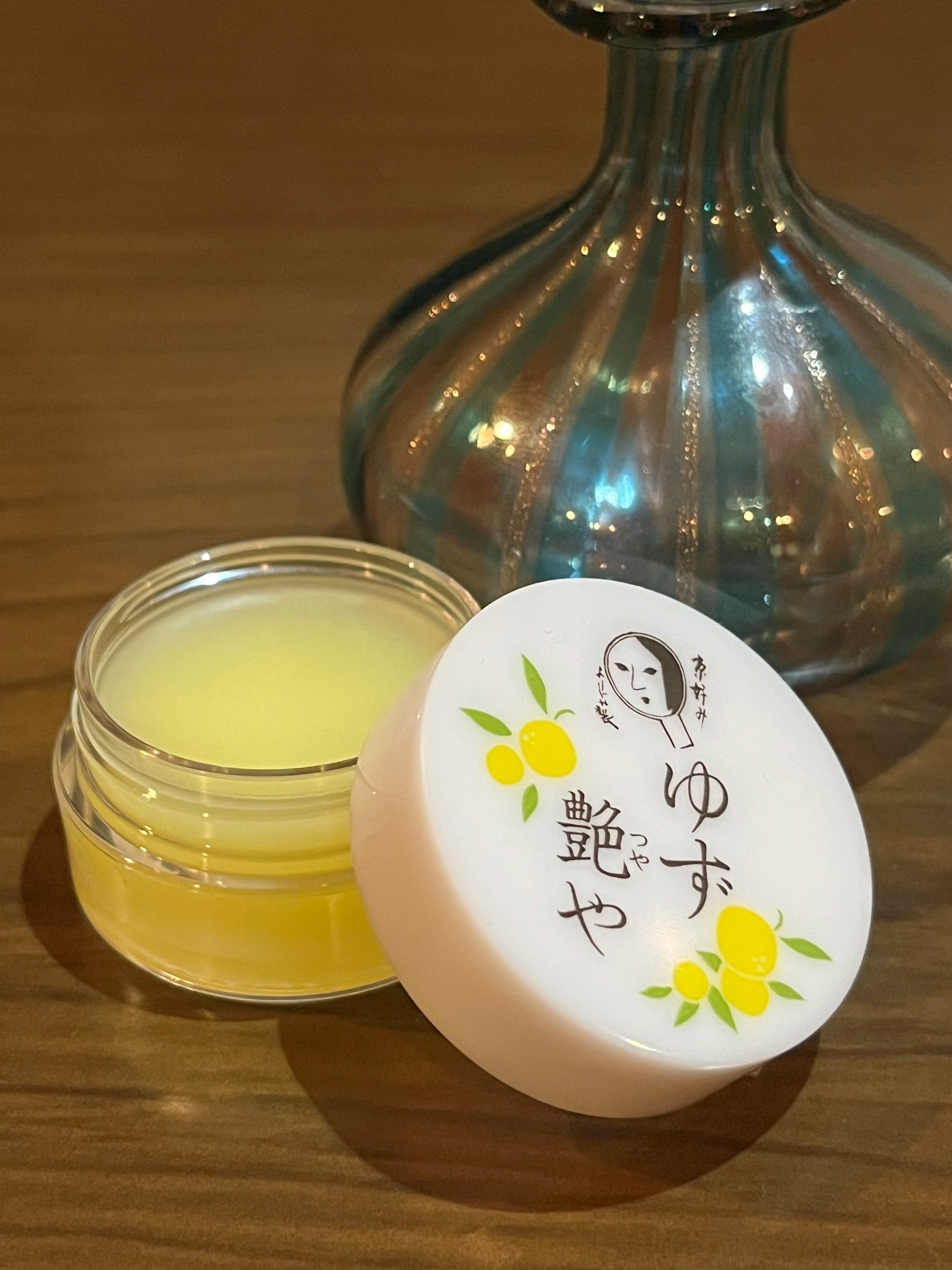 Sản phẩm chăm sóc da trong lọ trong suốt với kem màu vàng và nhãn trang trí