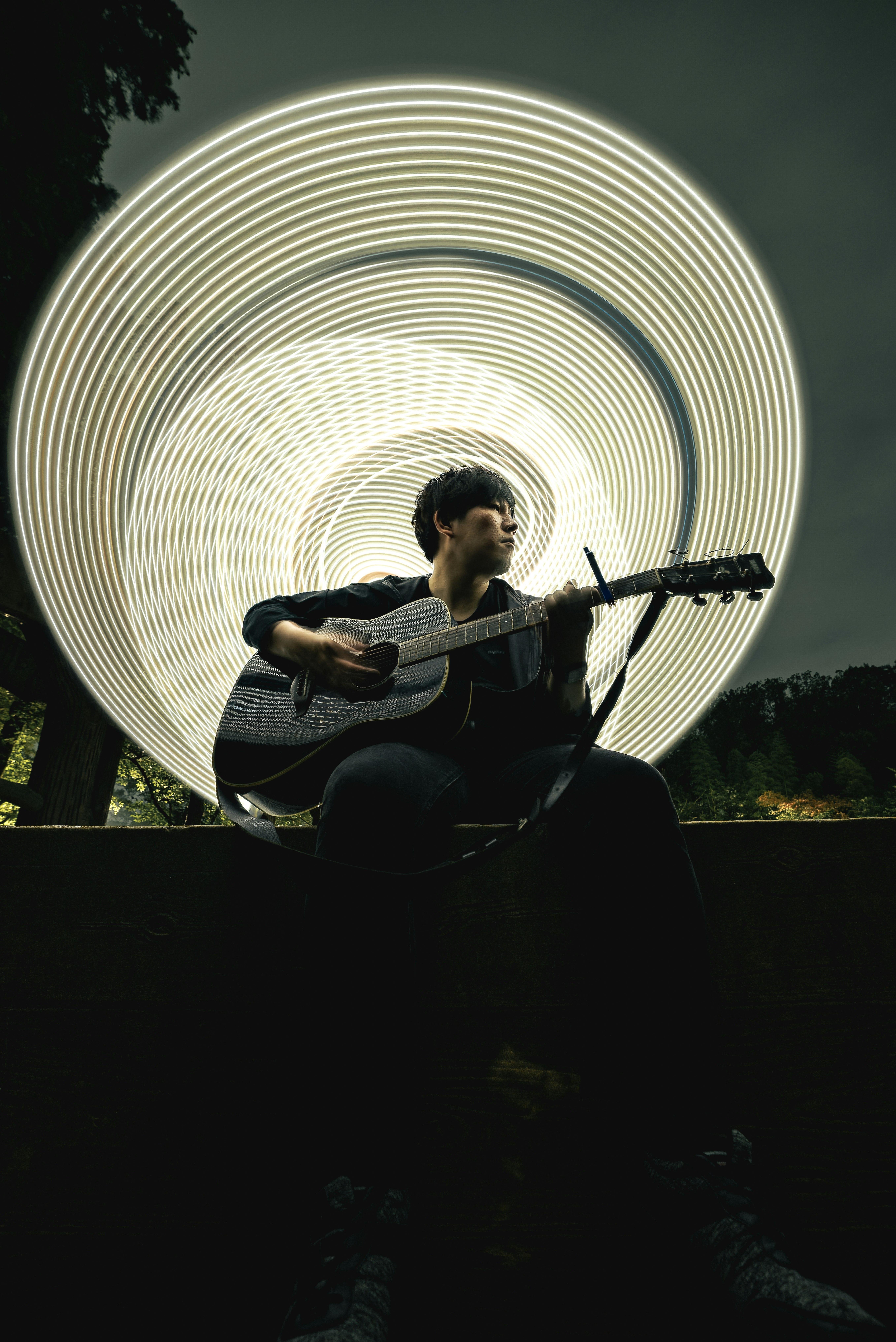 musicien jouant de la guitare dans un tunnel de lumière circulaire