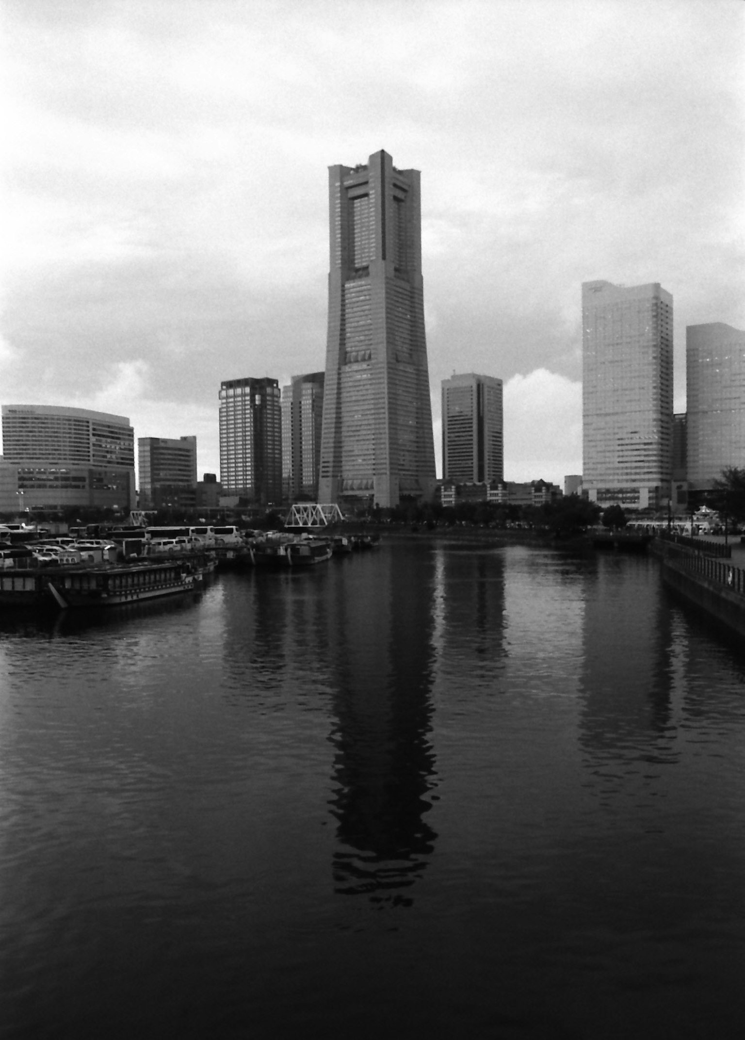 Monochrome photo of skyscrapers along a river