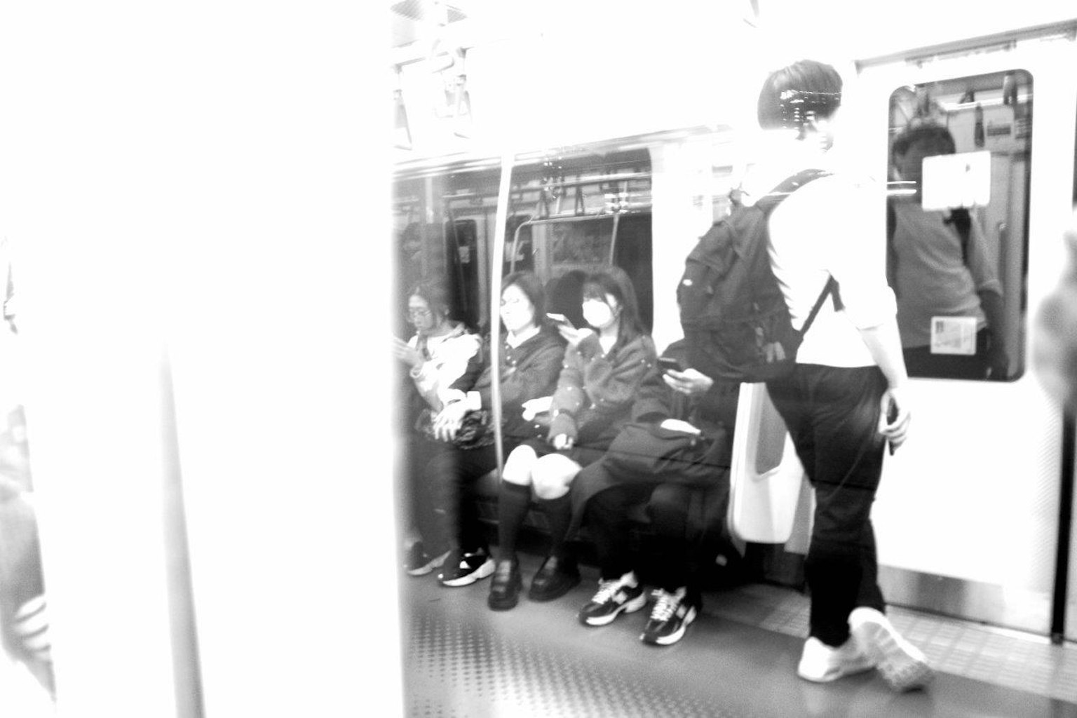 Hình ảnh đen trắng của hành khách tàu điện ngầm ngồi và đứng trong toa tàu