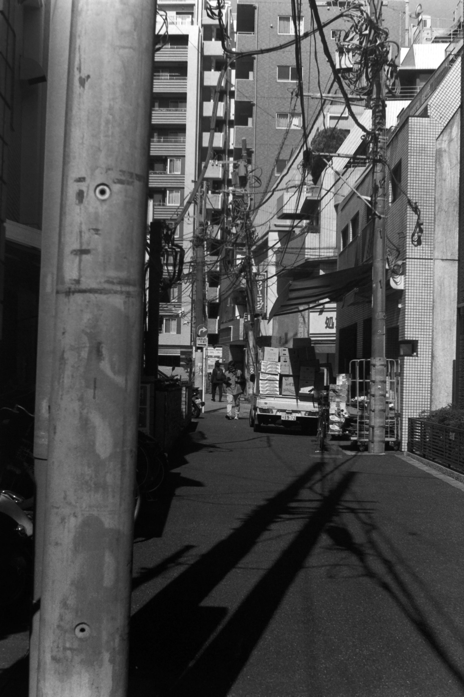 Schmale Gasse mit einem Versorgungsposten und Schatten Gebäude im Hintergrund