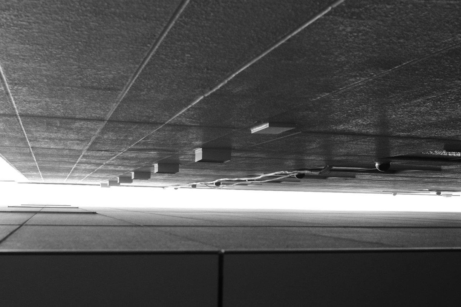 Photo architecturale en noir et blanc prise sous le plafond Lumière brillante visible au loin