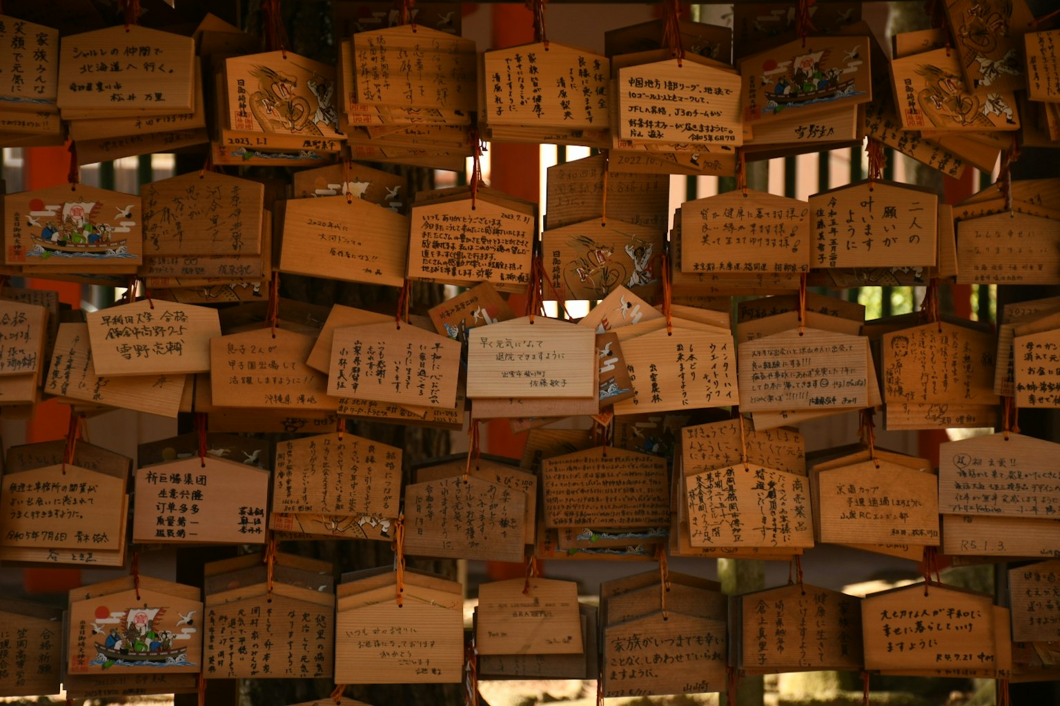 Una colección de placas ema de madera colgadas en un santuario