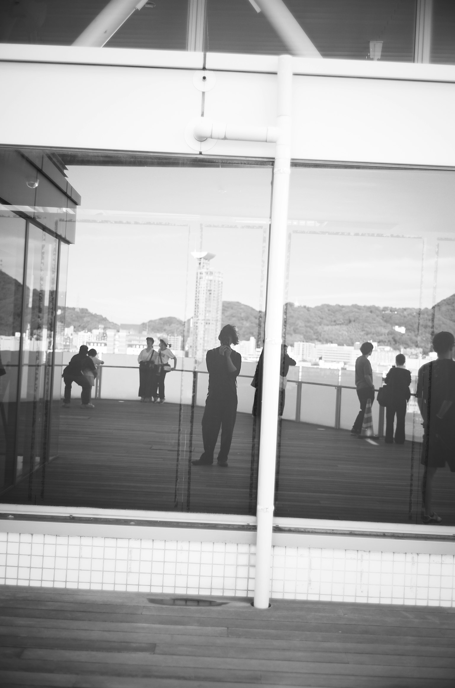 Pared de vidrio interior con reflejos en blanco y negro y siluetas de personas