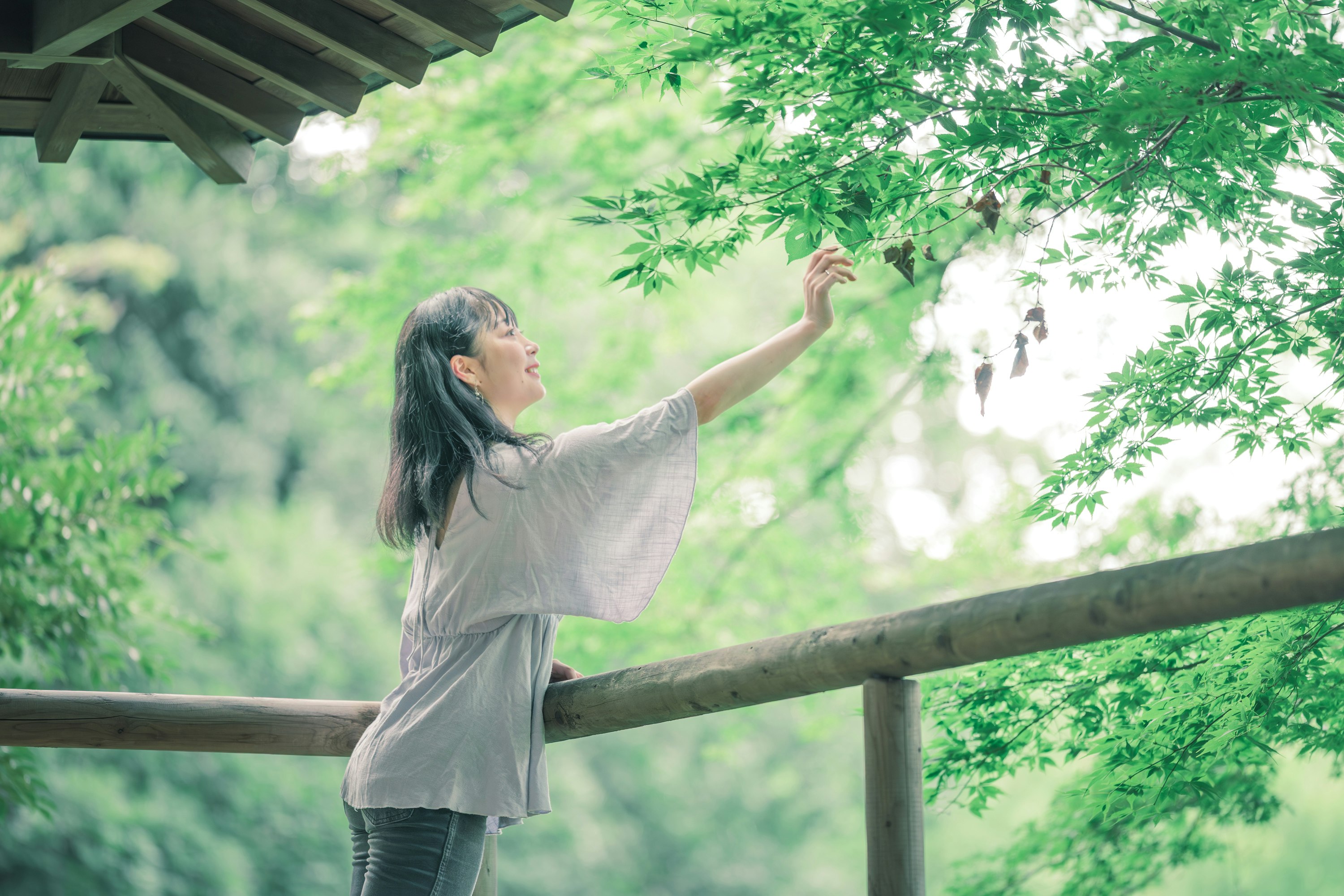 woman touching tree branches in summer shade