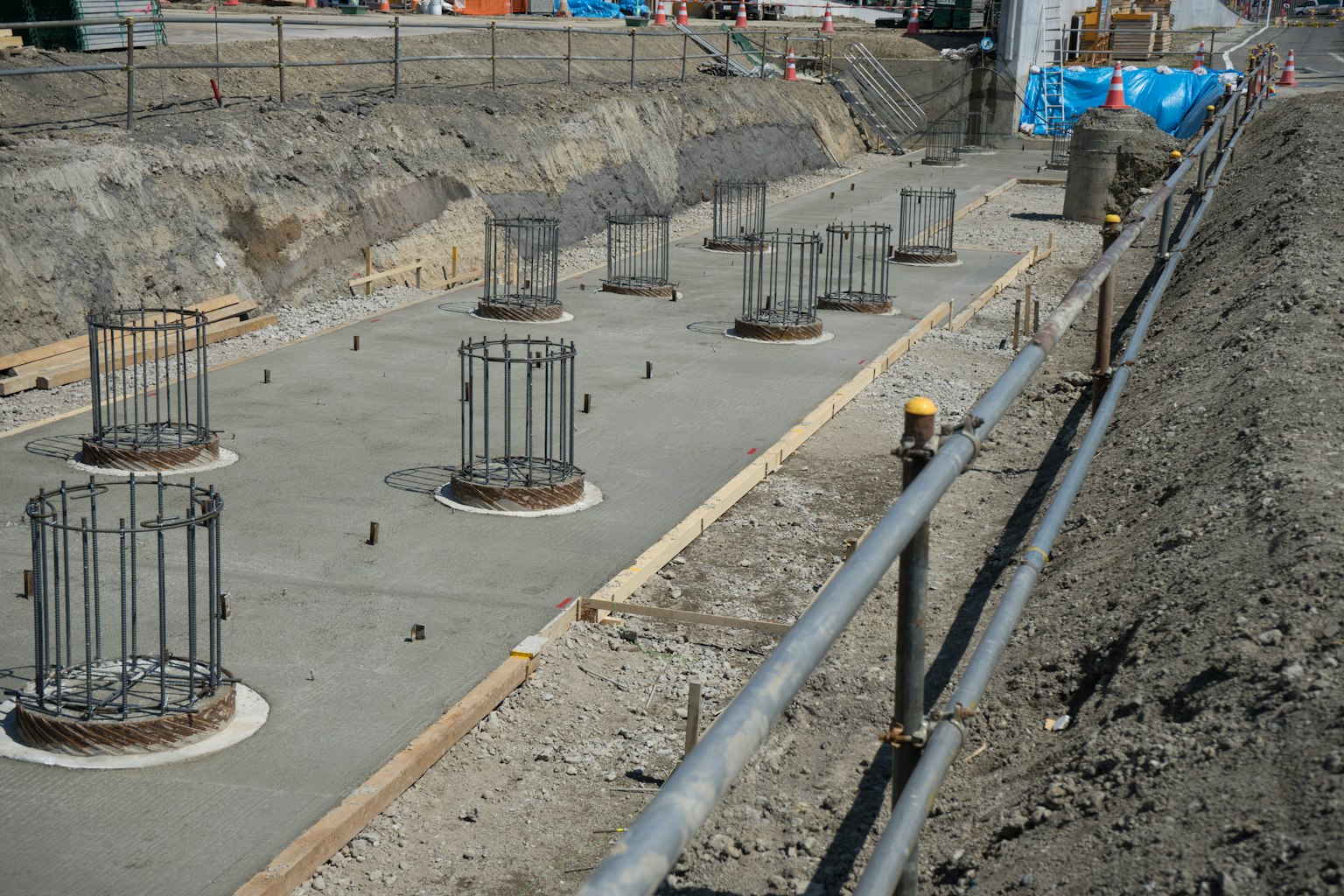 Situs konstruksi dengan fondasi beton dan kolom baja