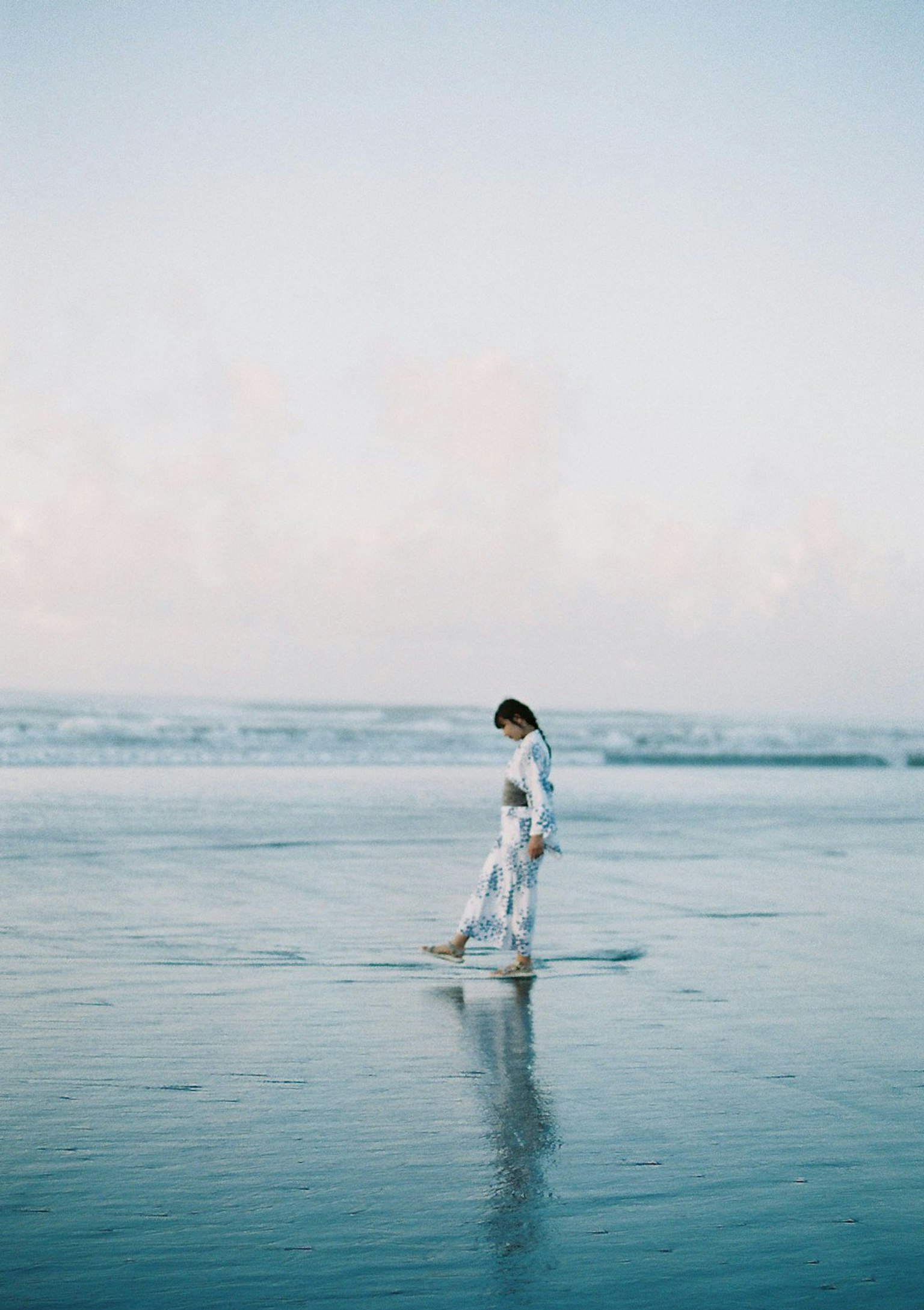 Silueta de una mujer caminando sobre el agua en la playa