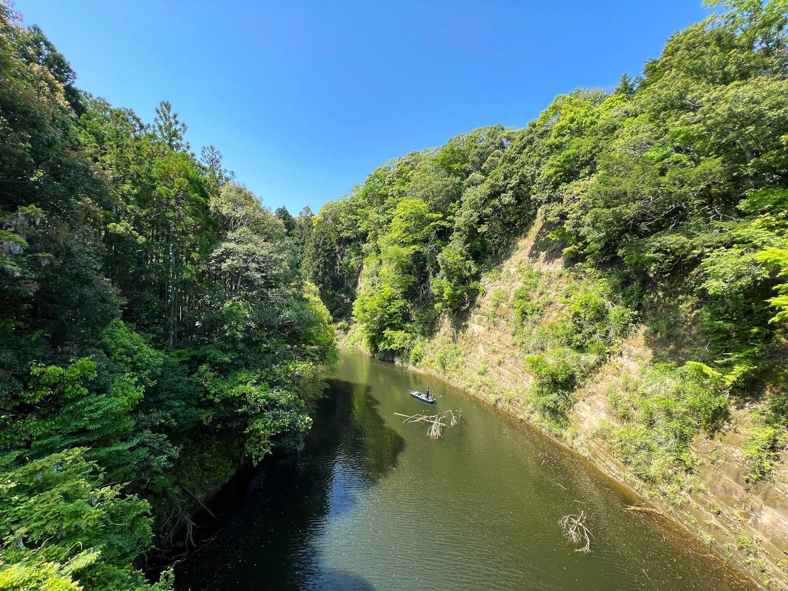 Valle lussureggiante e fiume tranquillo sotto un cielo blu chiaro
