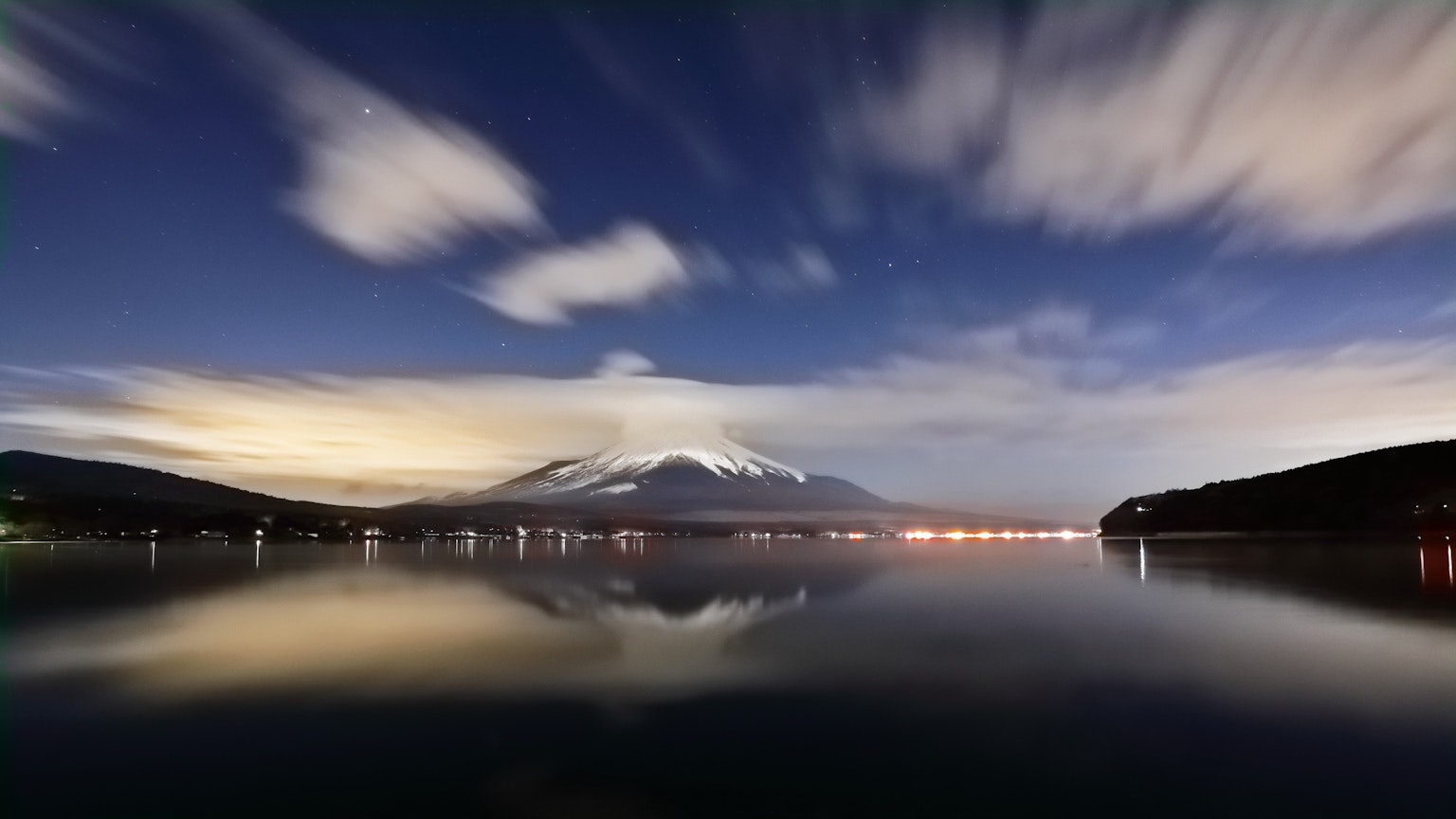 Beautiful Mount Fuji reflected in the calm lake under a night sky