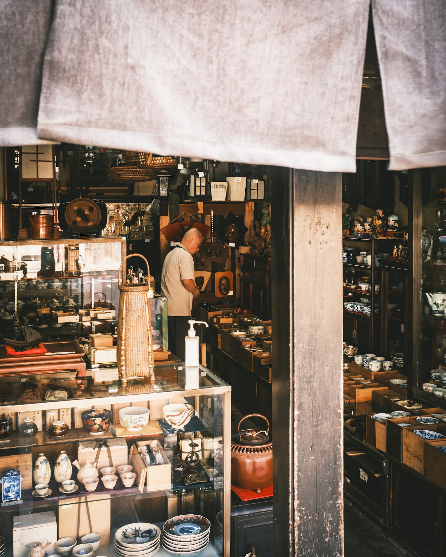 店主在满是复古陶器和各种物品的商店工作