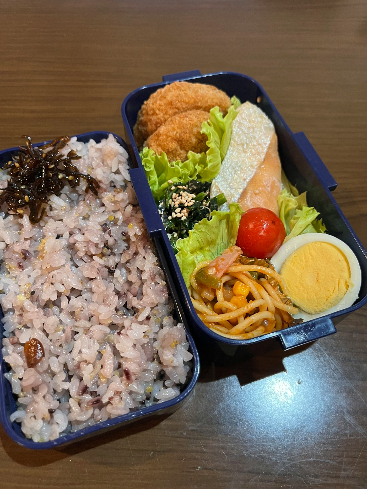 Eine bunte Bento-Box gefüllt mit Reis und verschiedenen Beilagen