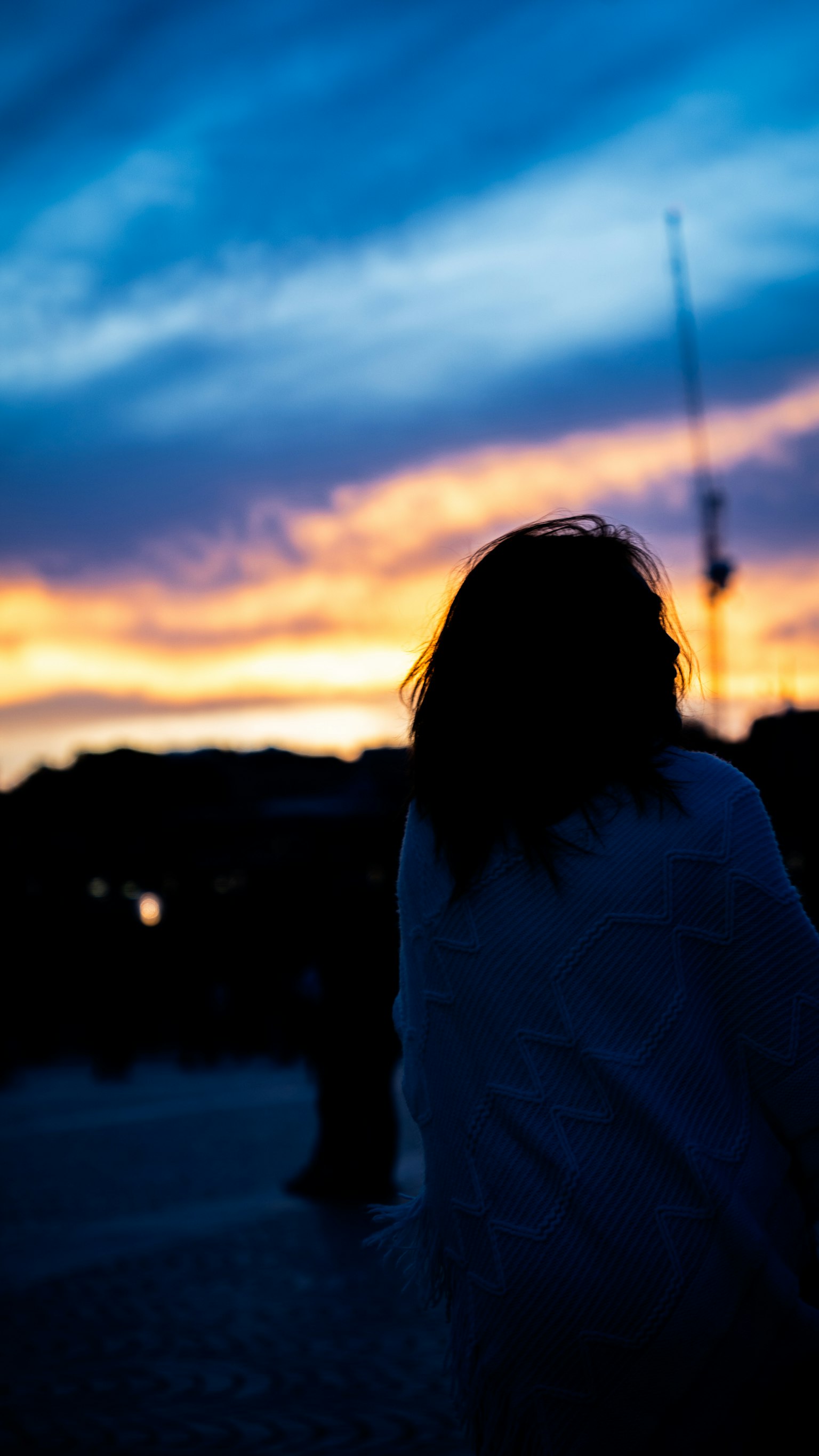 Silhouette seseorang di latar belakang langit senja yang berwarna
