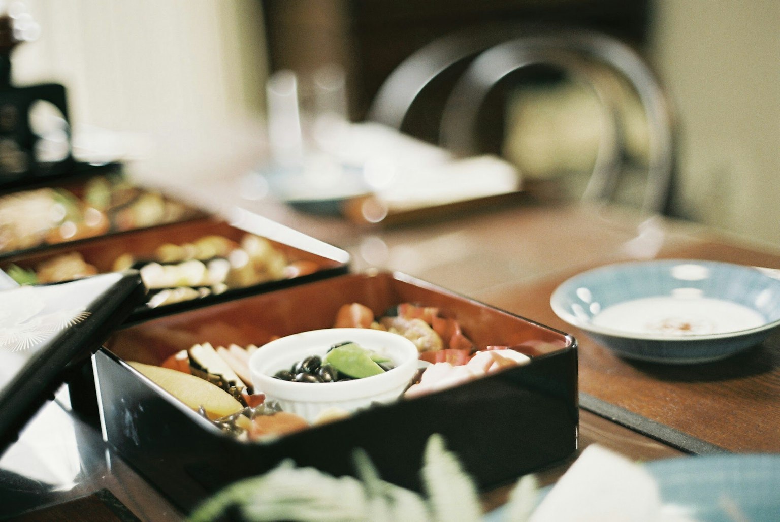 Une boîte à bento colorée remplie d'ingrédients variés sur une table en bois