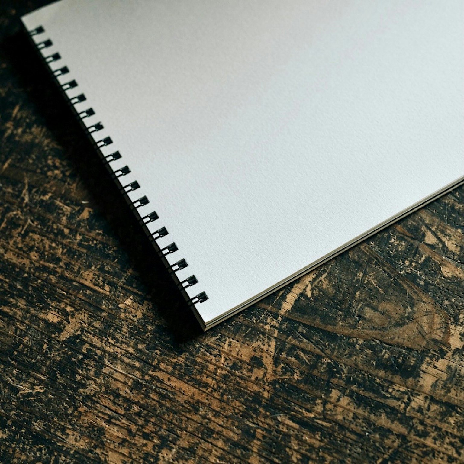 Buku sketsa putih di atas meja kayu