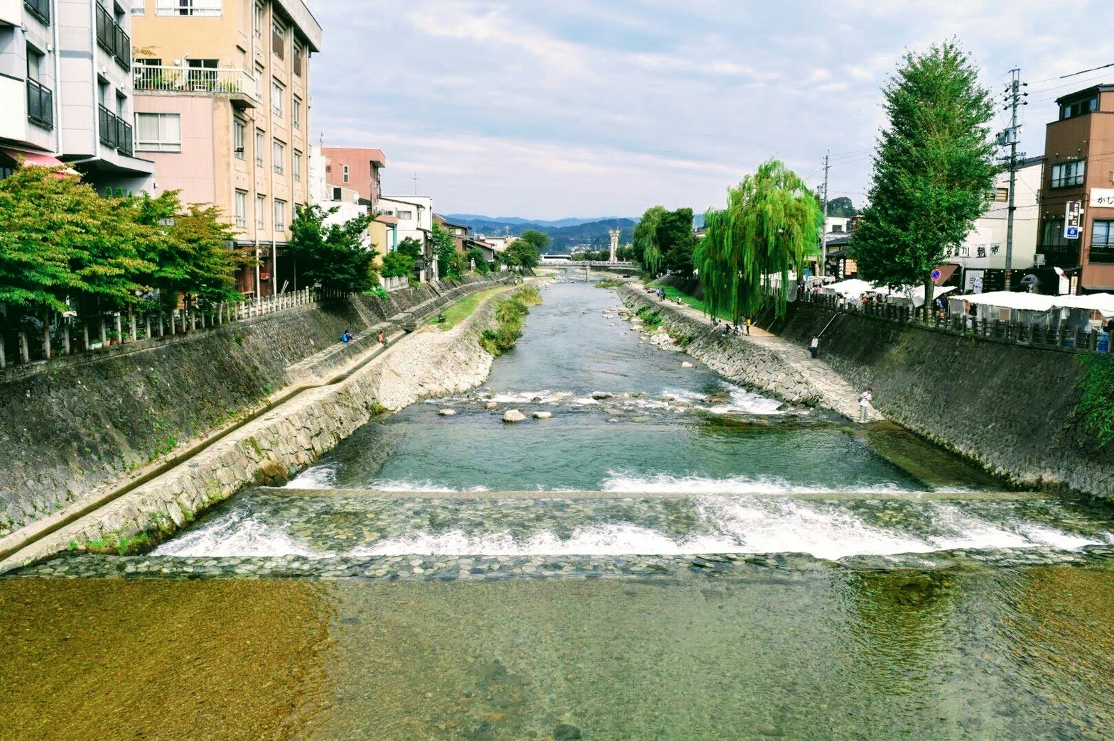 canale fluviale urbano con passeggiata e argini