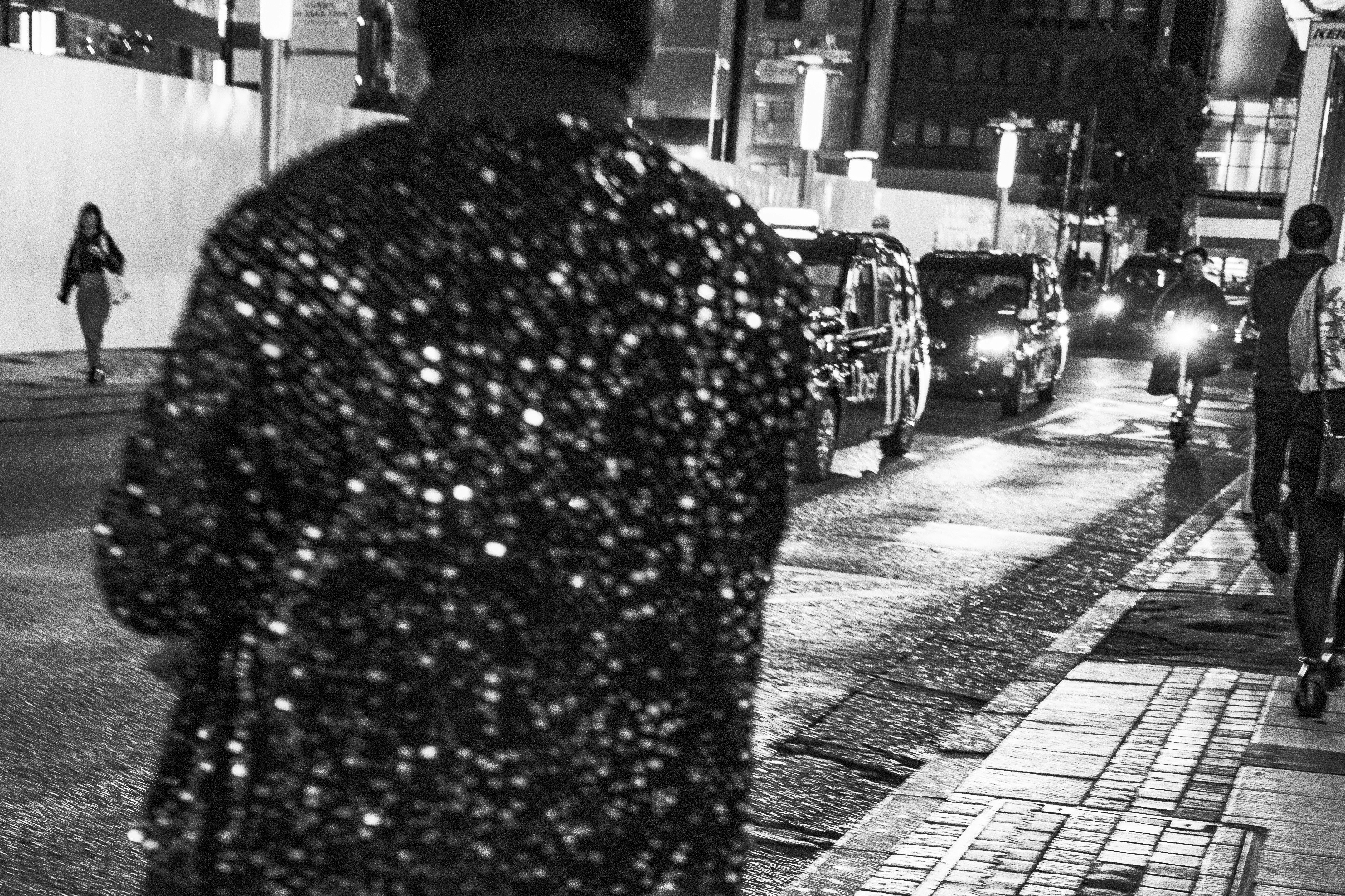 夜晚街灯下行走的人们与人行道