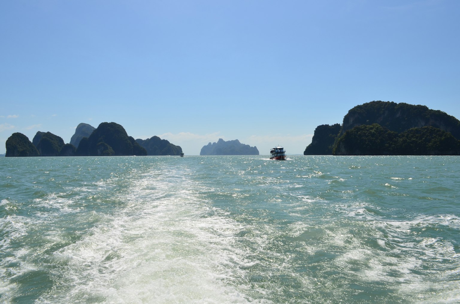 ทิวทัศน์ของมหาสมุทรสีน้ำเงินพร้อมเกาะหิน ร่องรอยของเรือที่มองเห็นในน้ำ