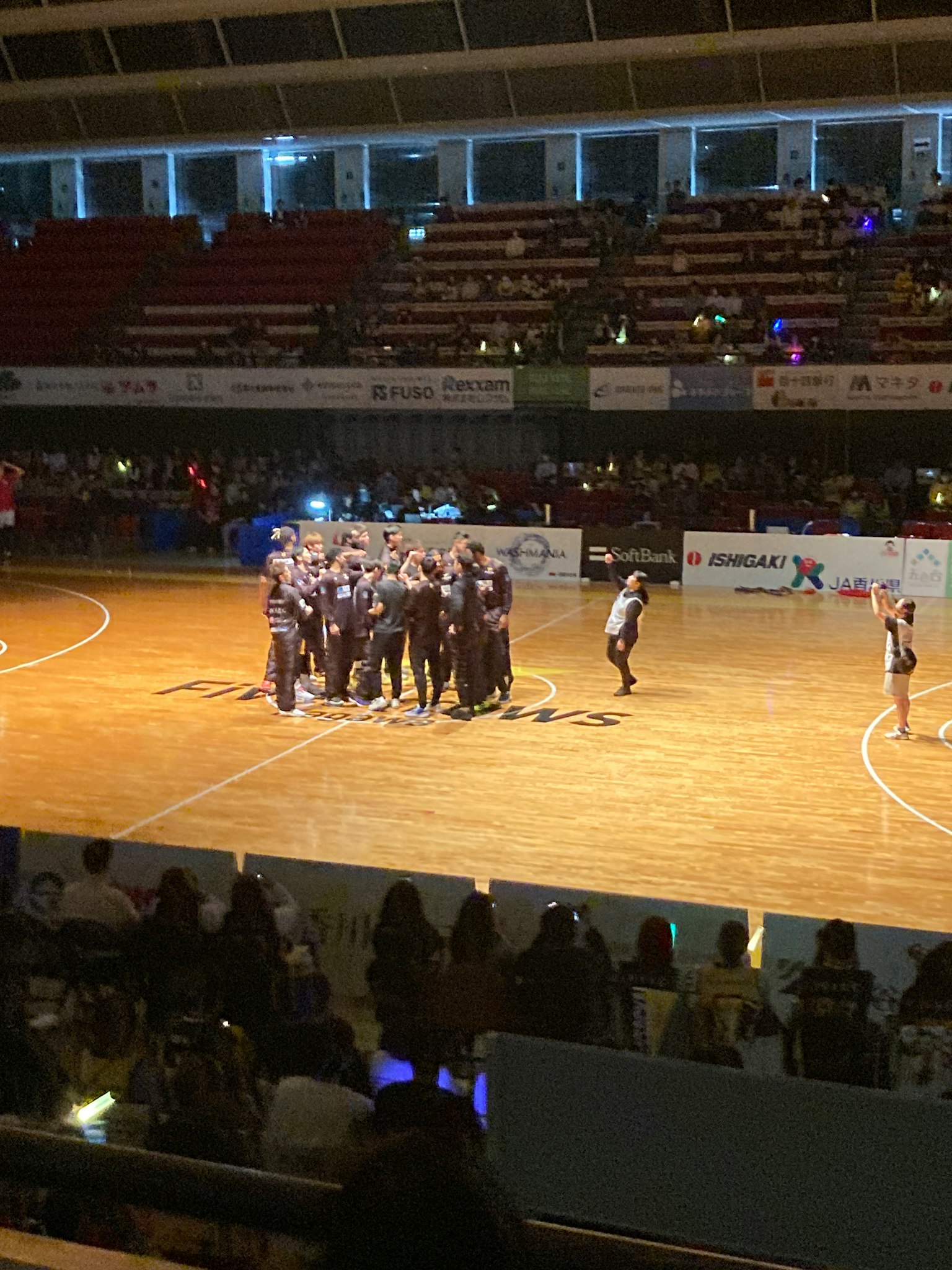 Interior de una arena con jugadores reunidos durante un partido de baloncesto