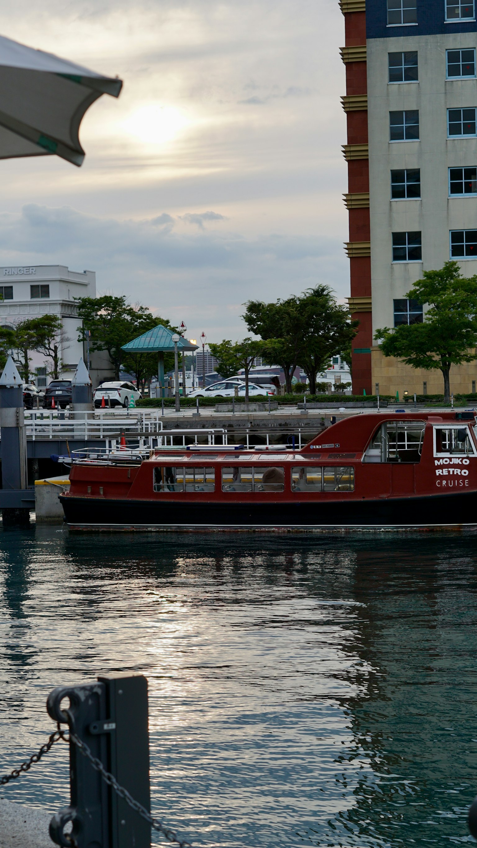 Red boat docked at the harbor with surrounding buildings