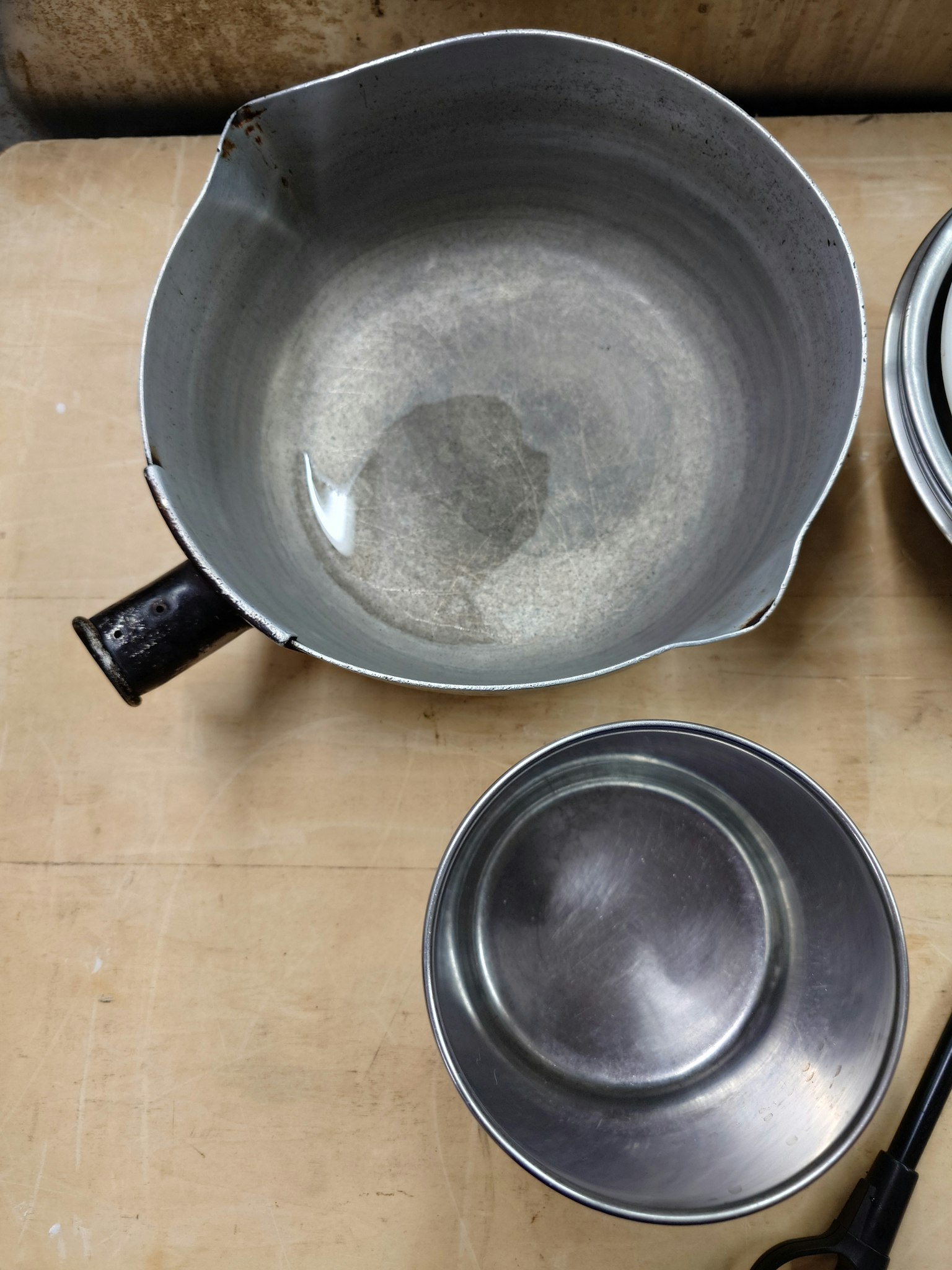 Metallschüssel und kleiner Teller auf einem Tisch platziert
