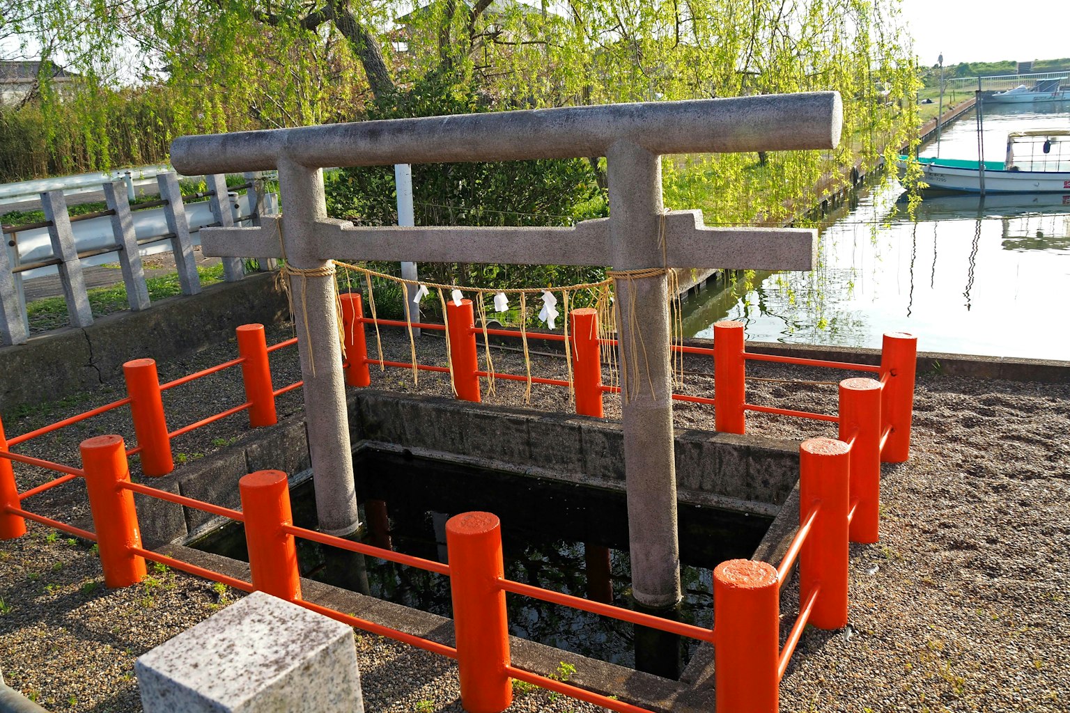 Puits sacré avec un torii et une clôture rouge