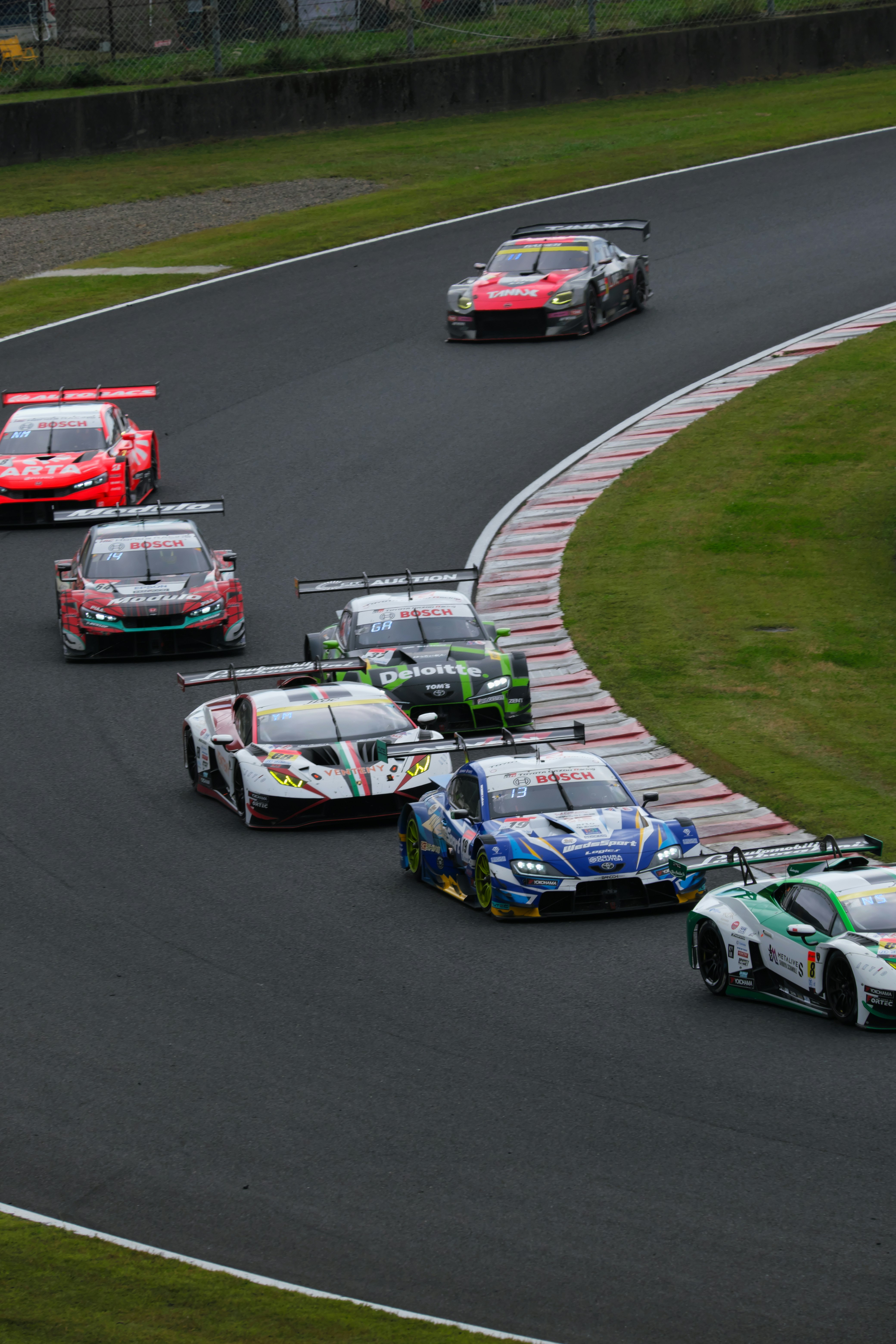 サーキットを走るレーシングカーの集団