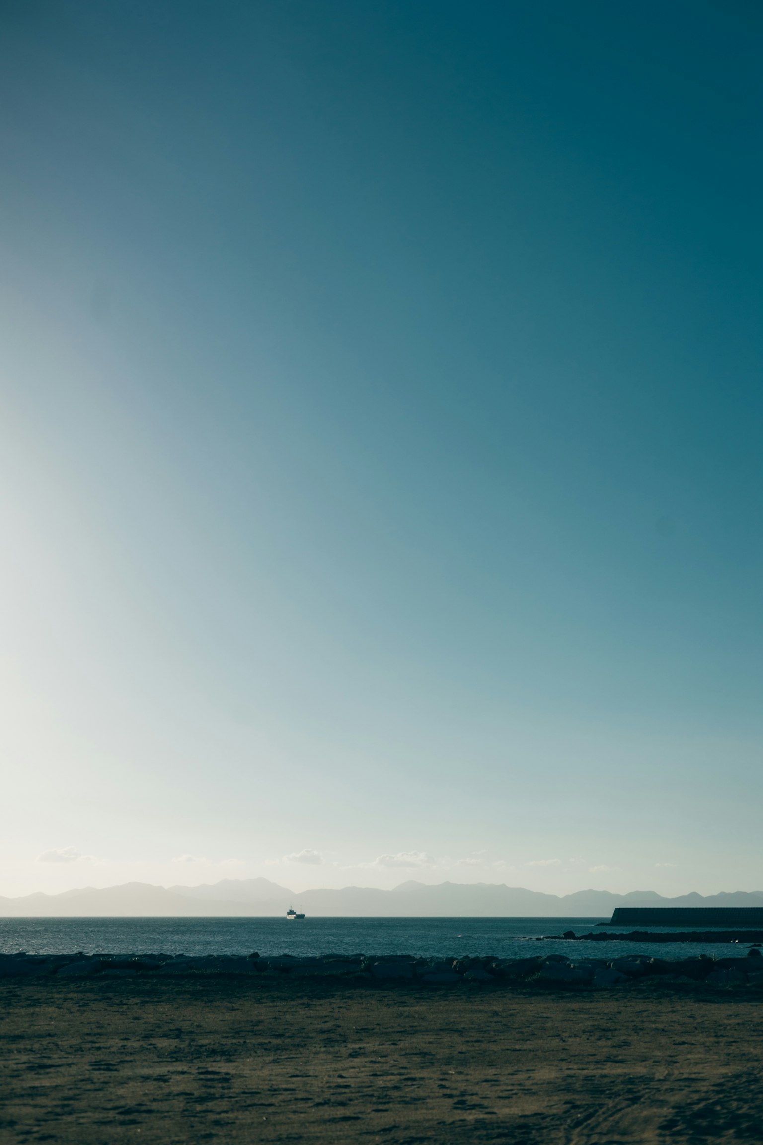Ruhige Ansicht von Meer und blauem Himmel mit fernen Bergen