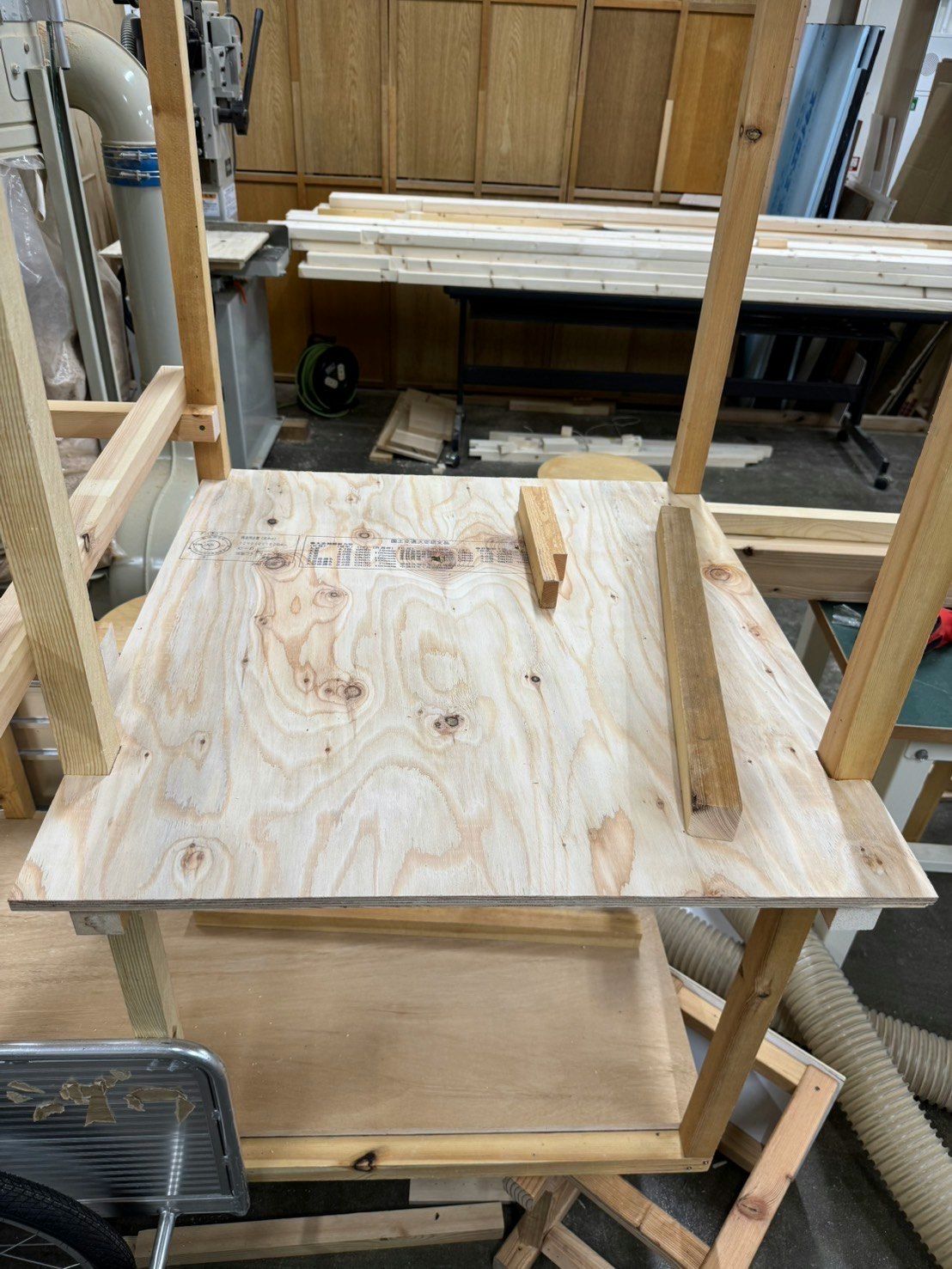 Tablero de madera sobre un banco de carpintería con herramientas