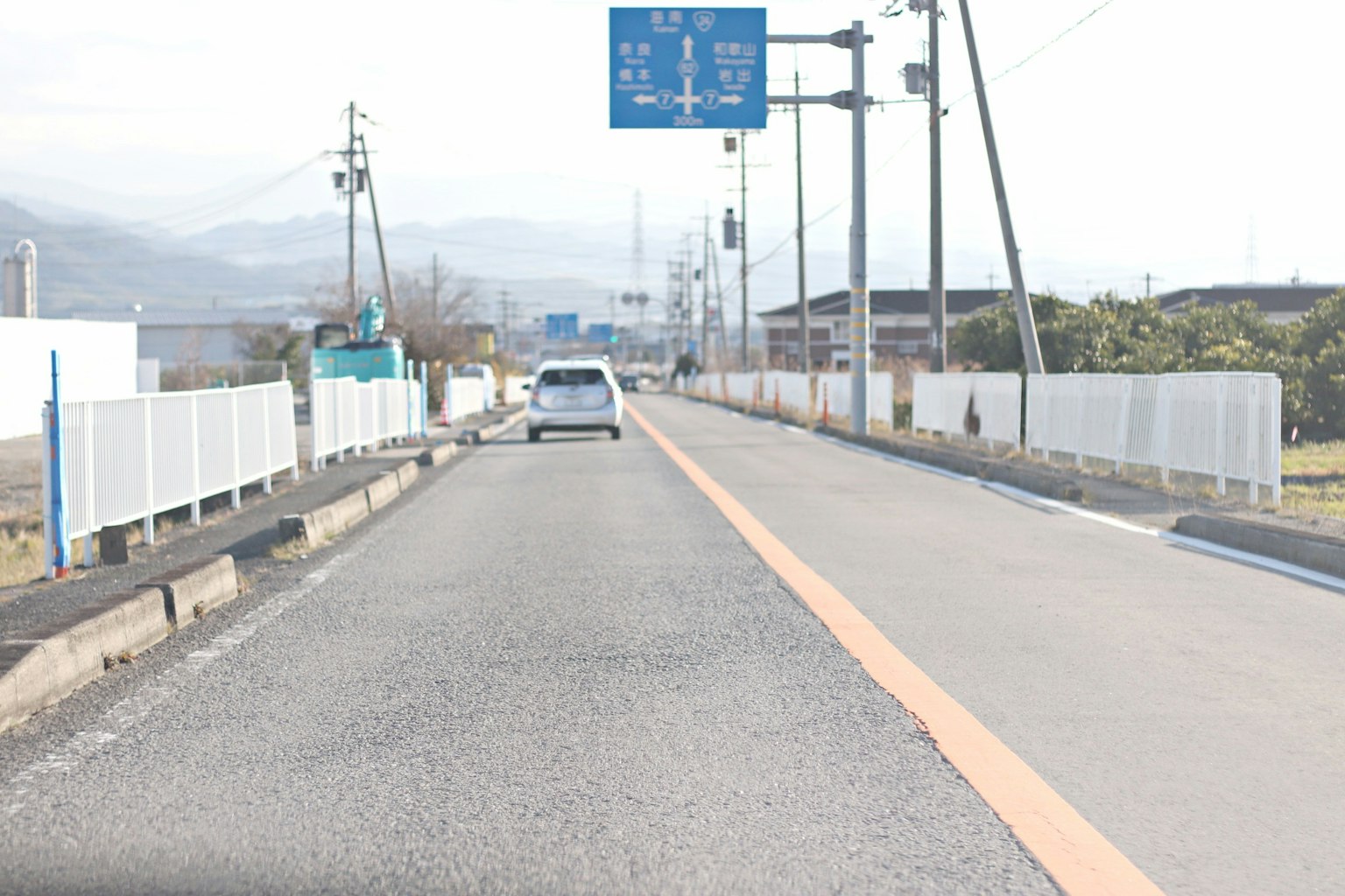 Vista de una carretera con un coche y señales de tráfico