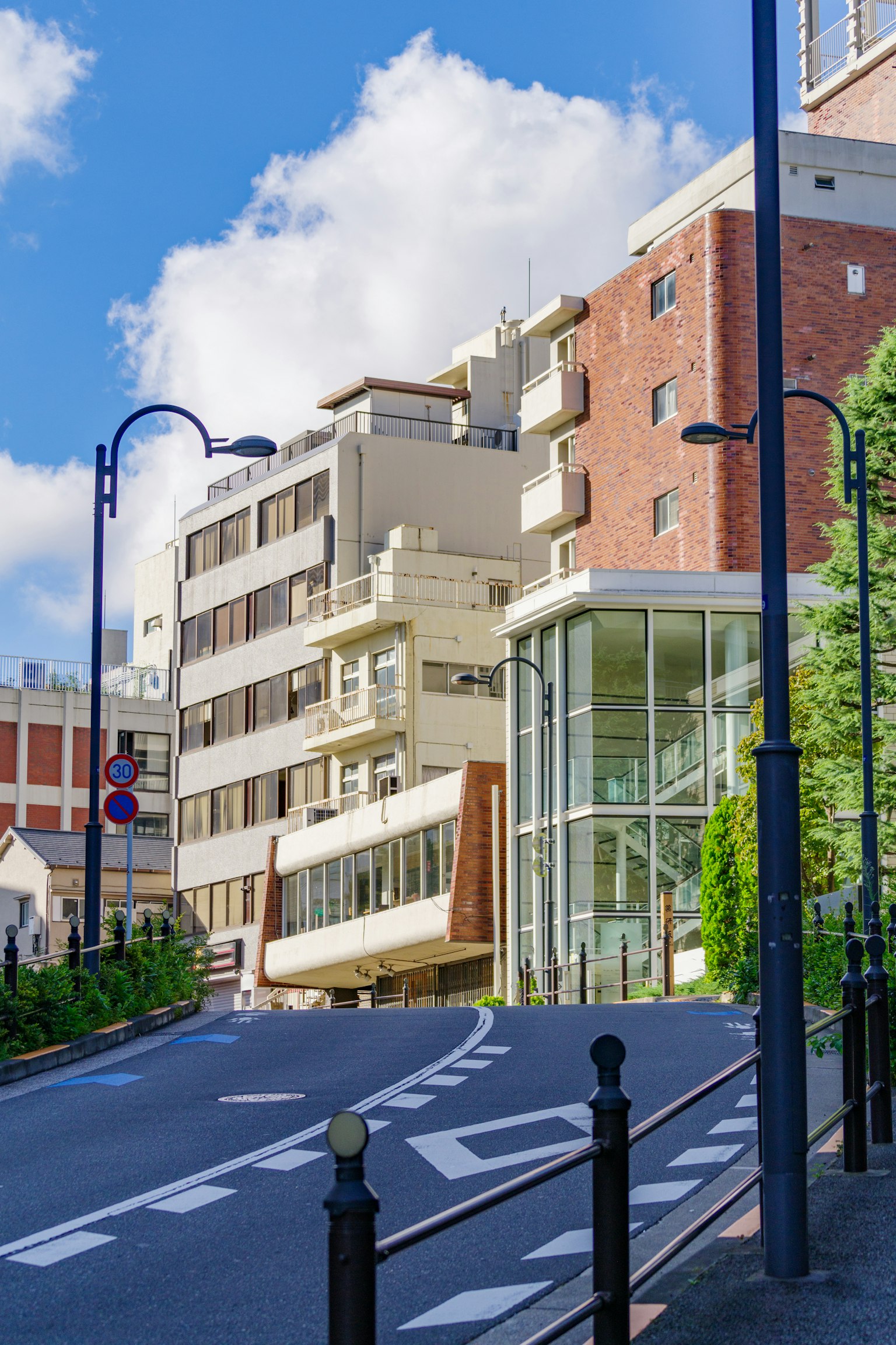 Vue de rue en pente avec des bâtiments modernes sous un ciel bleu