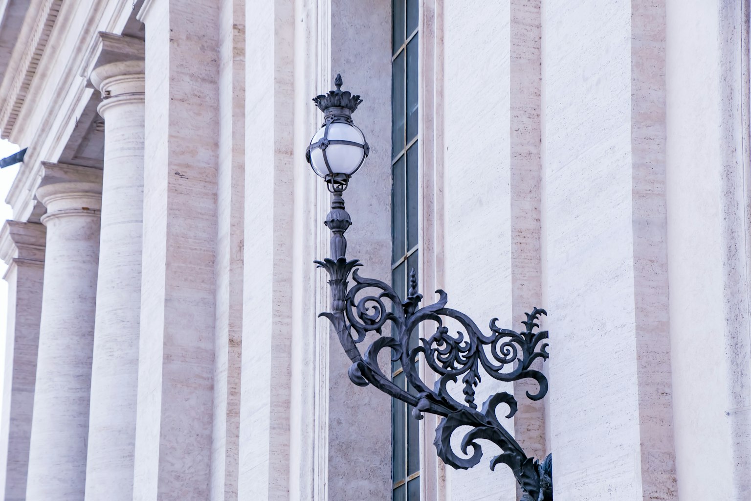 Lámpara de calle decorativa unida a un edificio con hermosa fachada a rayas