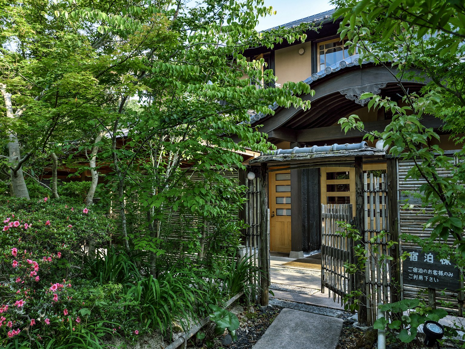 Entrance of a traditional Japanese building surrounded by greenery