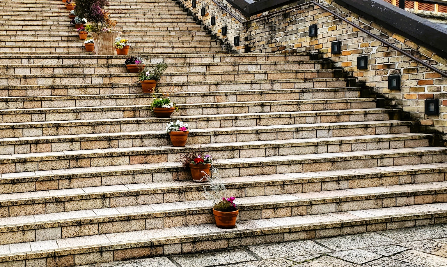 Eine geflieste Treppe geschmückt mit Blumentöpfen, die nach unten führt