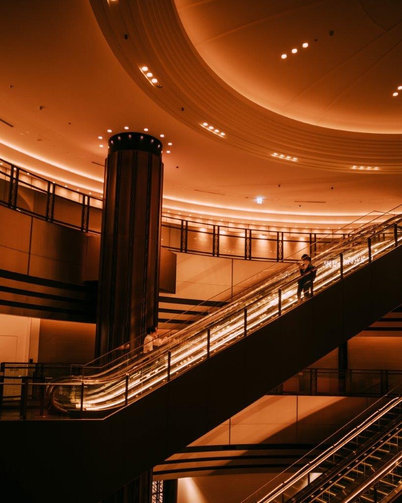 escalier intérieur courbe éclairé en orange et atrium