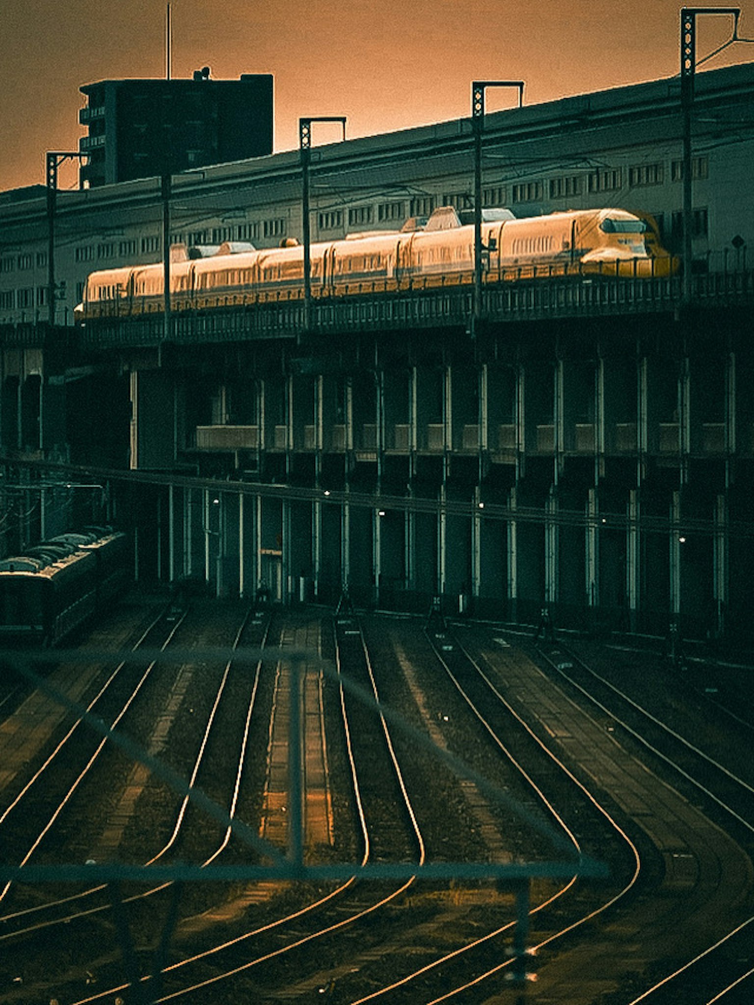 รถไฟชินคันเซนที่วิ่งผ่านพระอาทิตย์ตกพร้อมรางรถไฟ