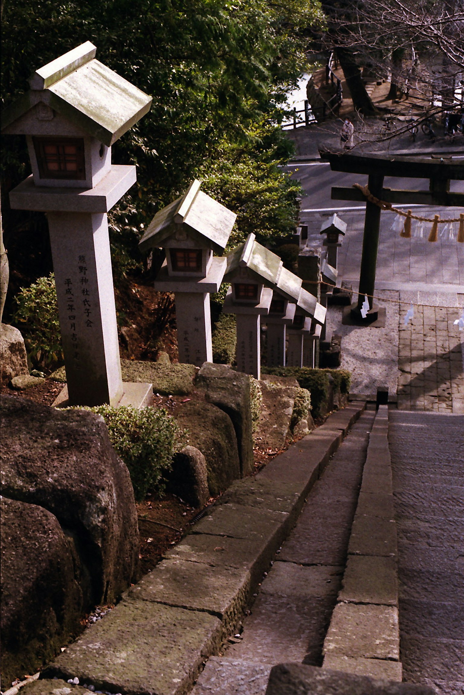 Steinlaternen entlang einer Treppe zu einem Torii
