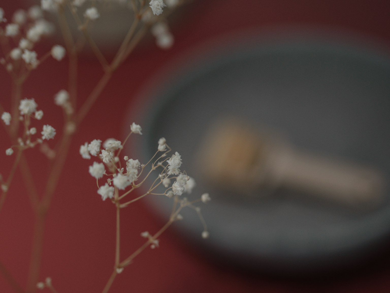 Fiori bianchi delicati e un cucchiaio di legno su un tavolo semplice