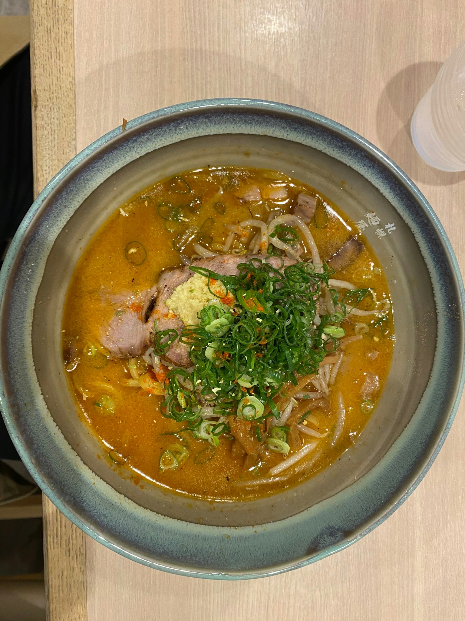 ราเมนที่มีเนื้อและต้นหอมในน้ำซุปเข้มข้น