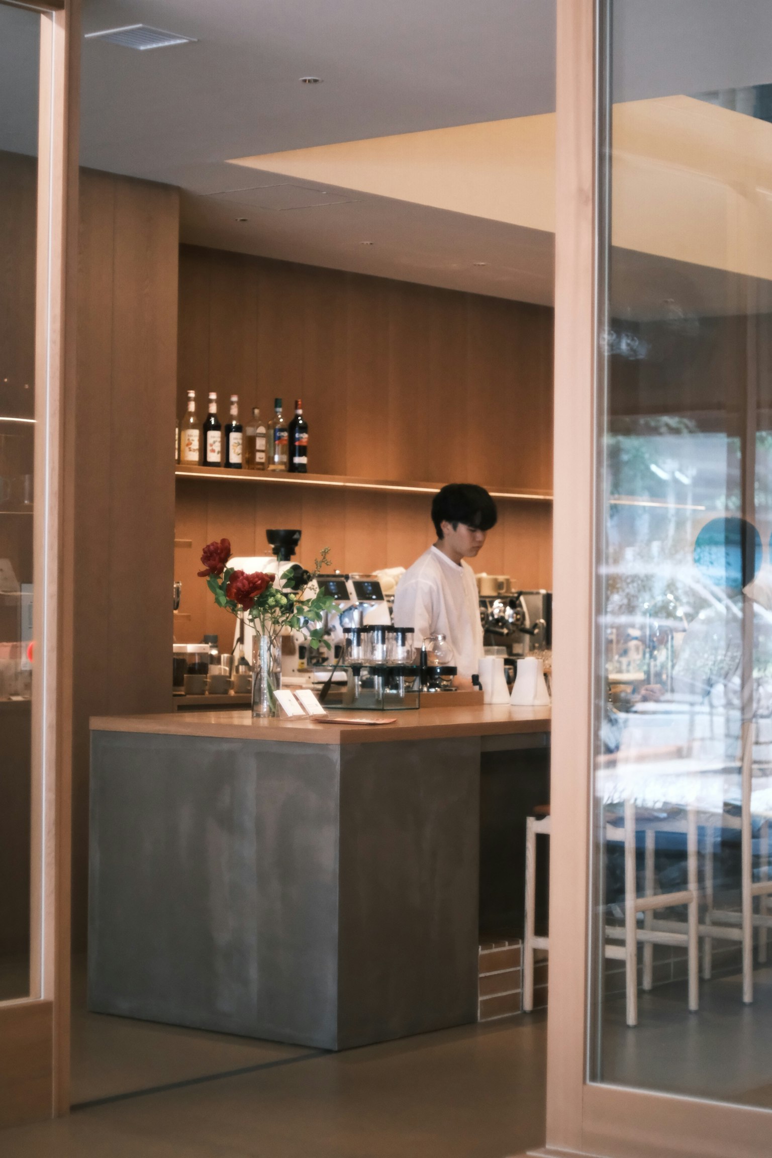 ภาพของบาริสต้าที่ทำงานที่เคาน์เตอร์กาแฟในบรรยากาศที่เรียบง่ายและทันสมัย