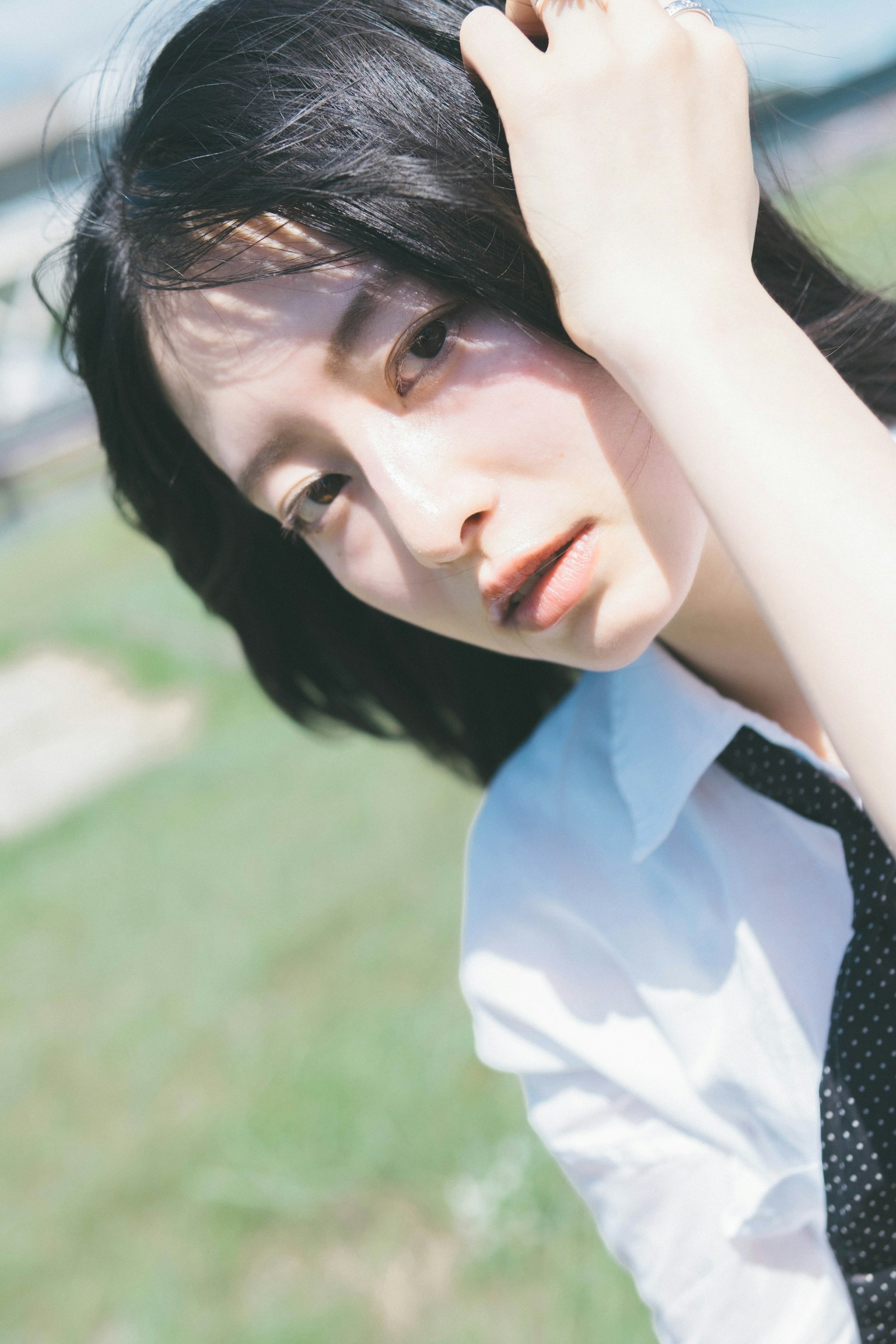 Portrait of a woman in a white shirt and tie with a green background