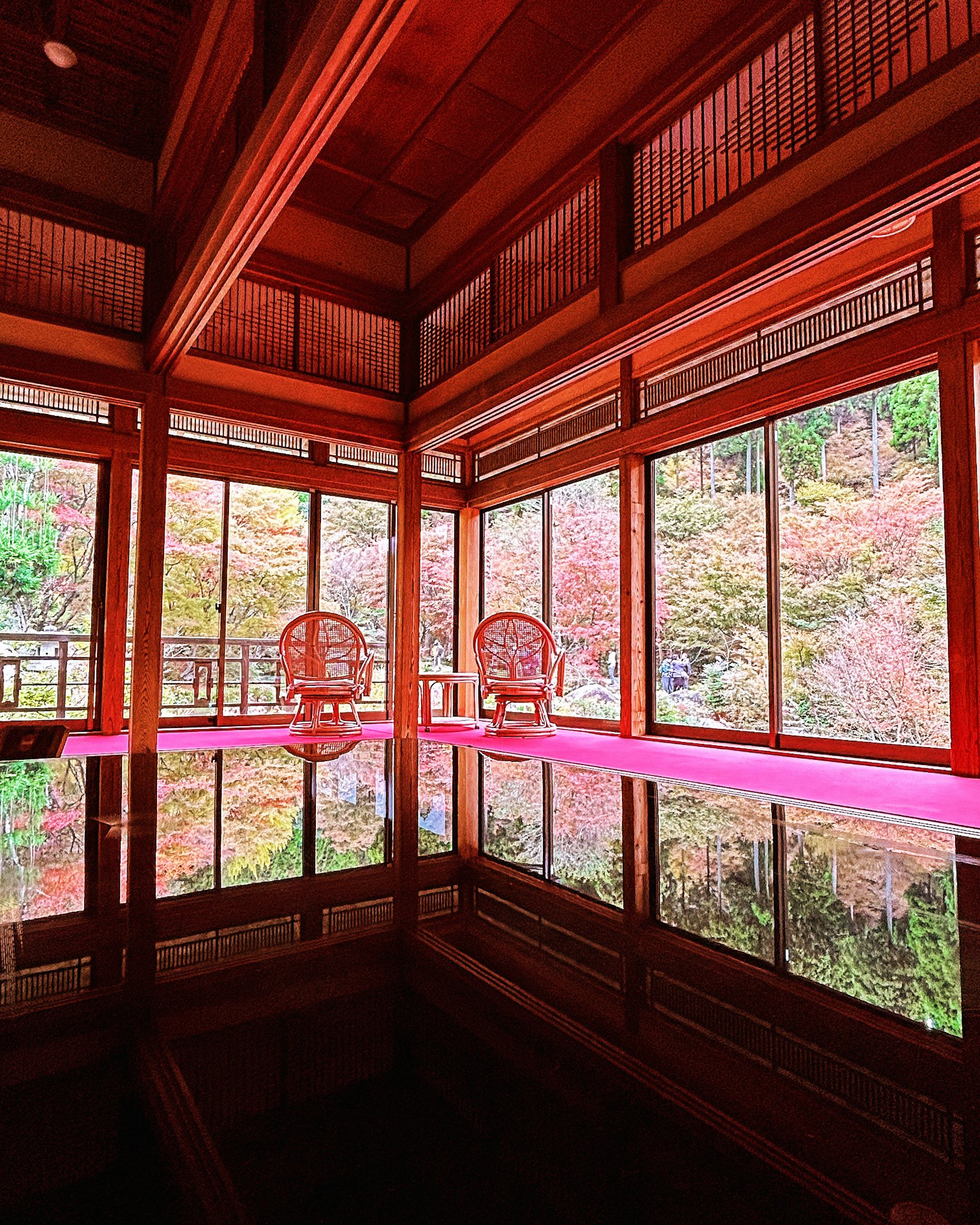 Traditional Japanese room with beautiful autumn foliage view and reflective floor featuring two chairs