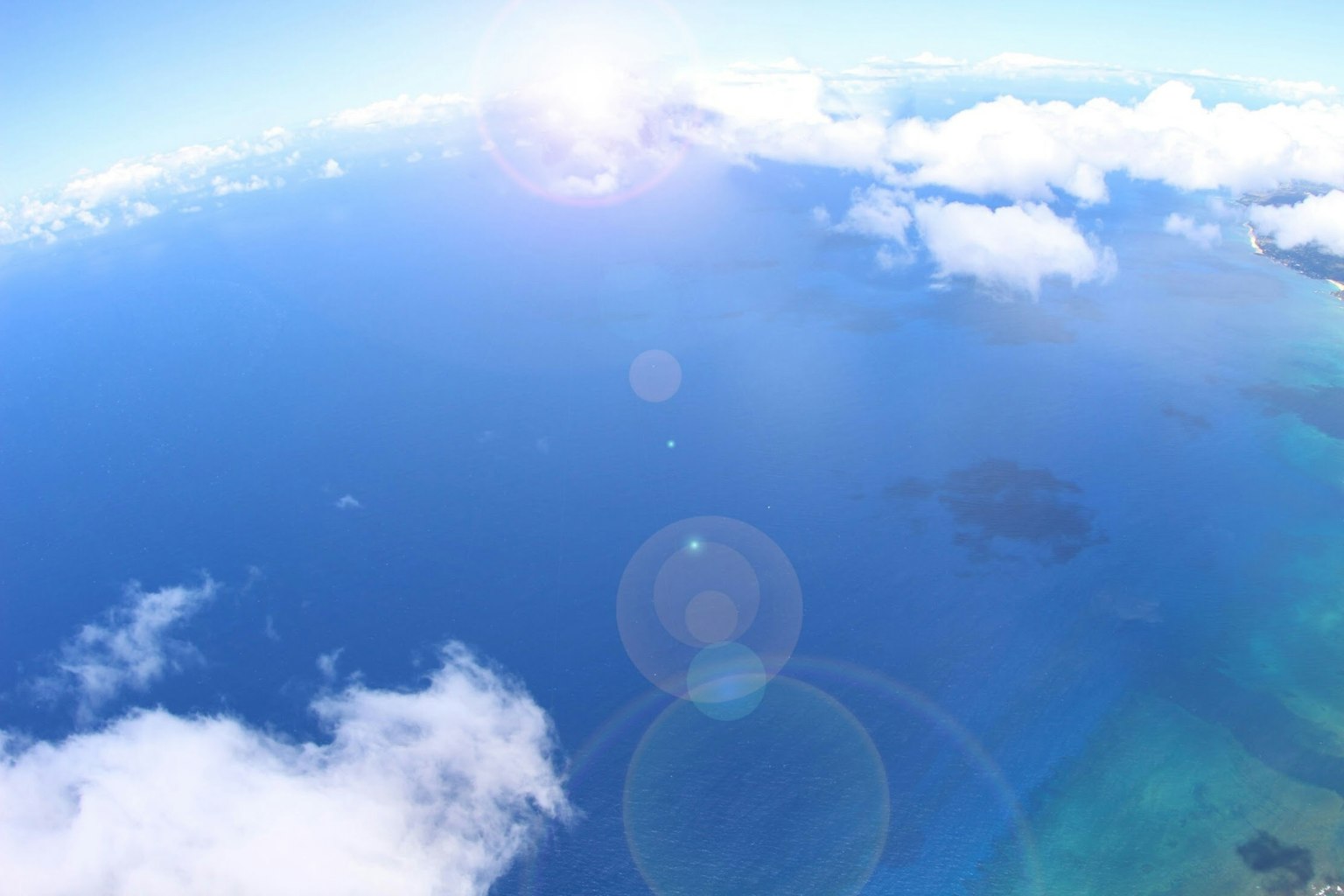 Luftaufnahme eines blauen Ozeans und weißer Wolken unter einem hellen Himmel