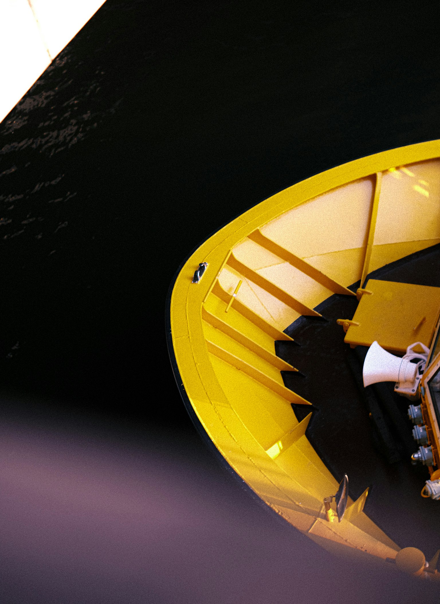 Un escalier de bateau jaune avec une partie de la surface de l'eau noire visible