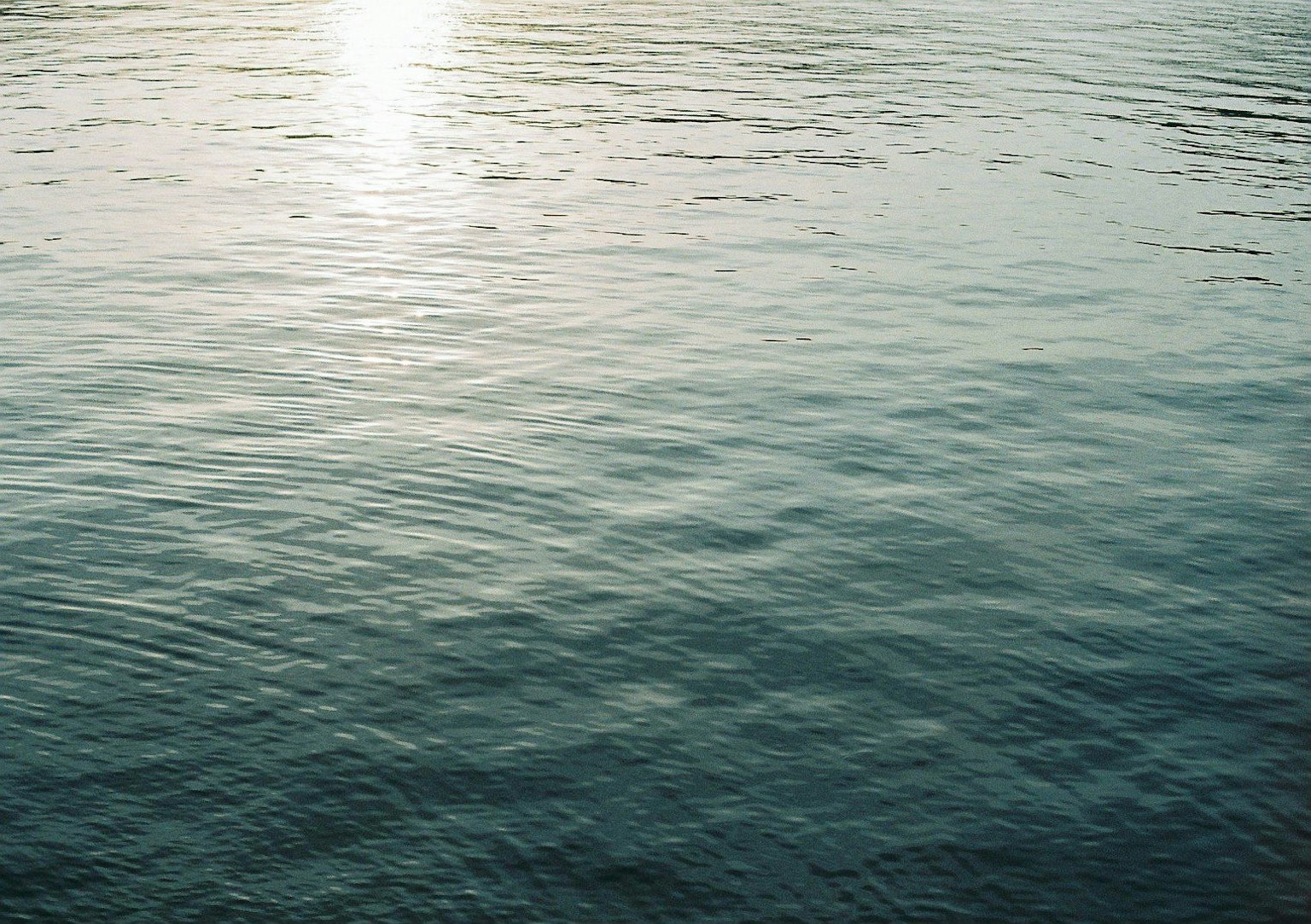 Ruhige Wasseroberfläche, die Licht reflektiert