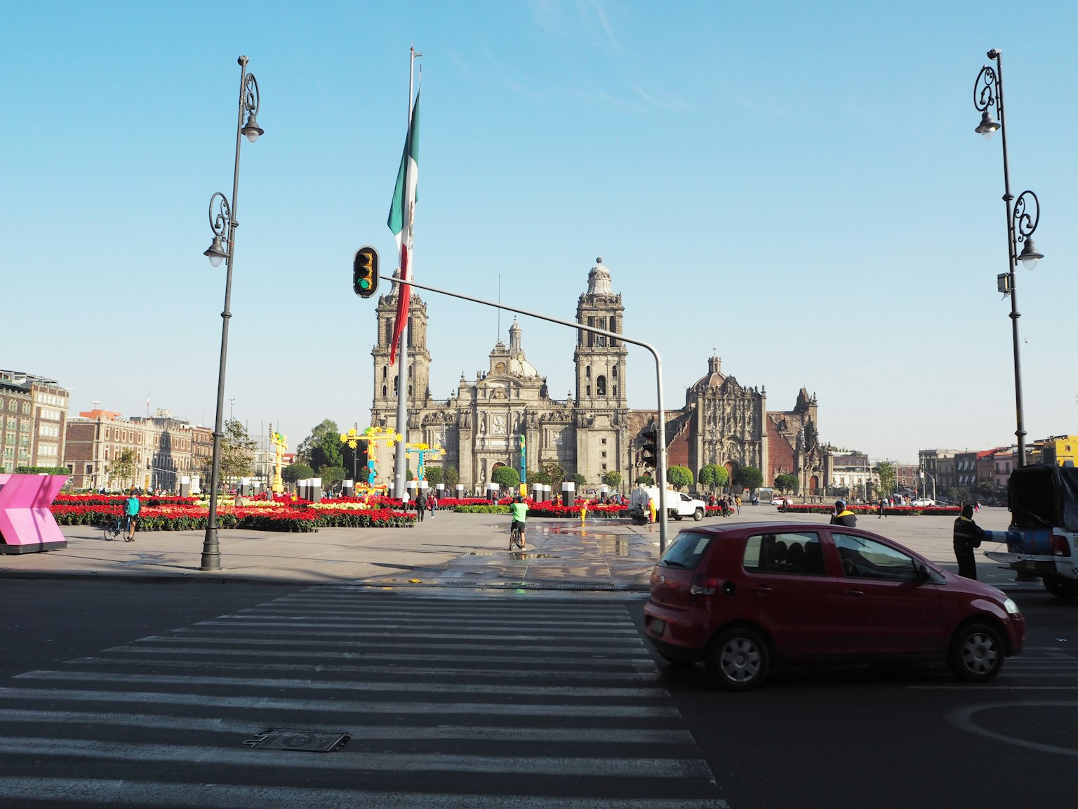 Cảnh quan một quảng trường ở Thành phố Mexico với xe đỏ và các tòa nhà lịch sử